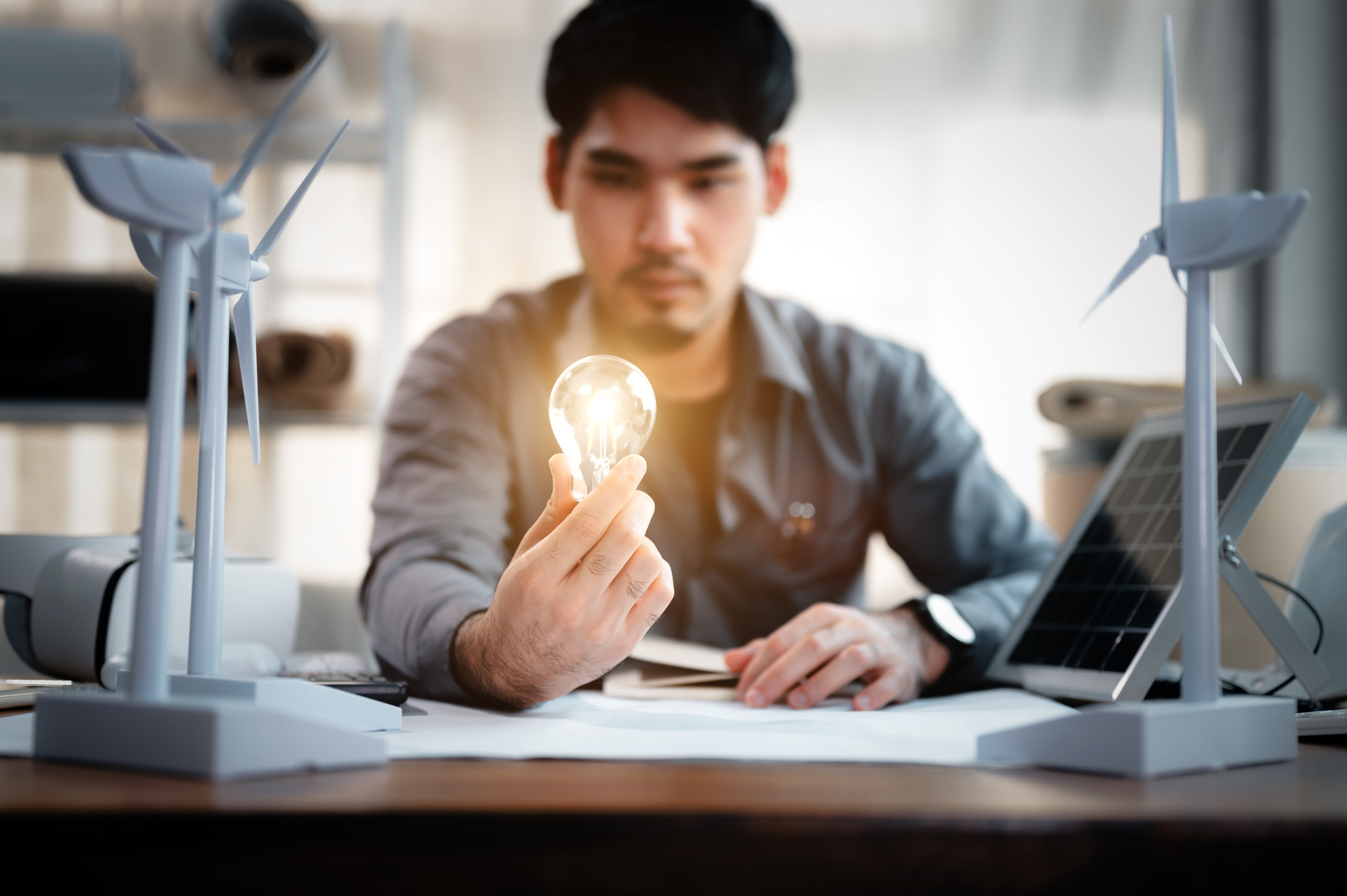 energy engineer holding light bulb in modern offic b207dff5e1aa1a83f8ca