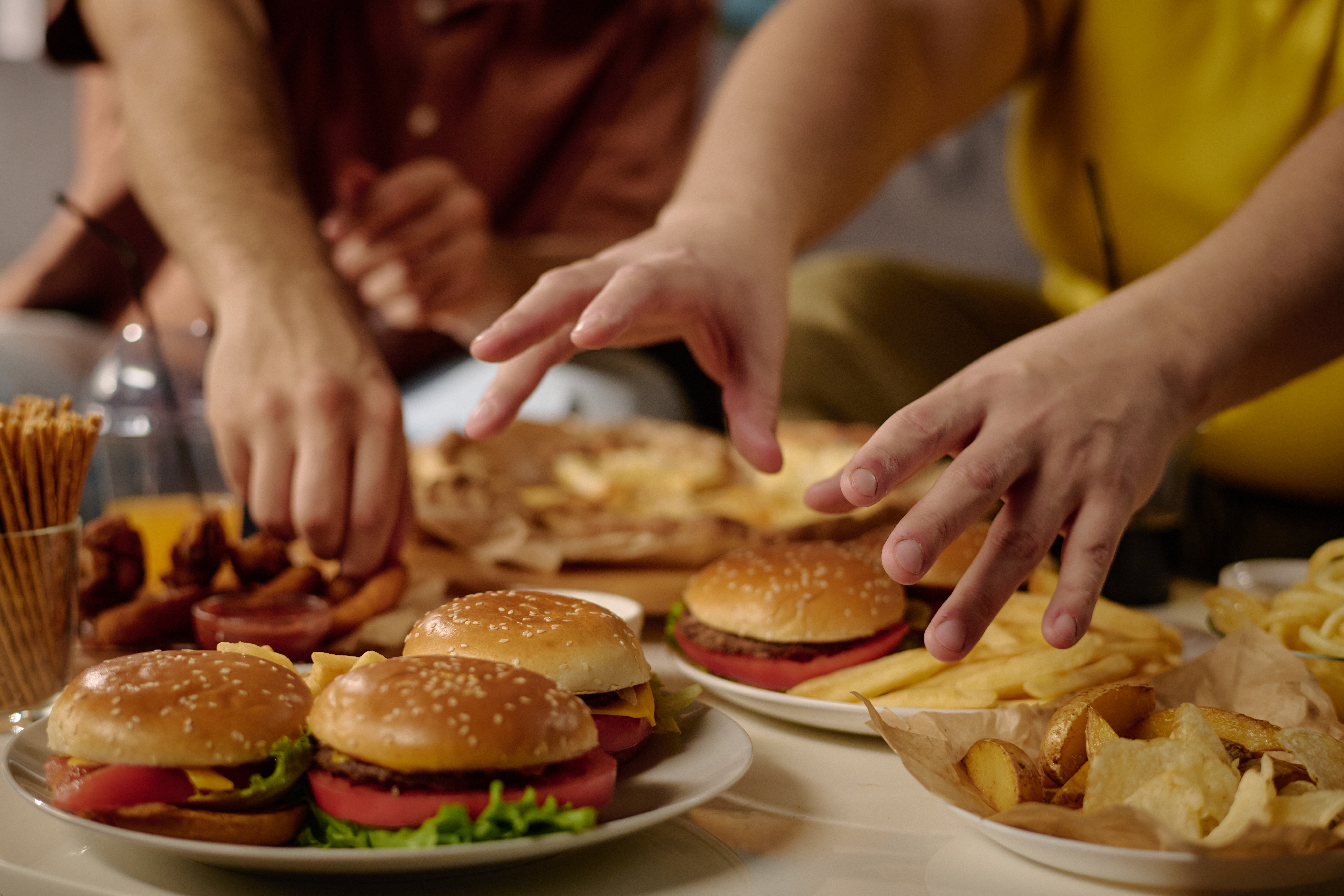 enjoying burgers and chips with friends indoors f1f0f0f5d983d6e6a5c6