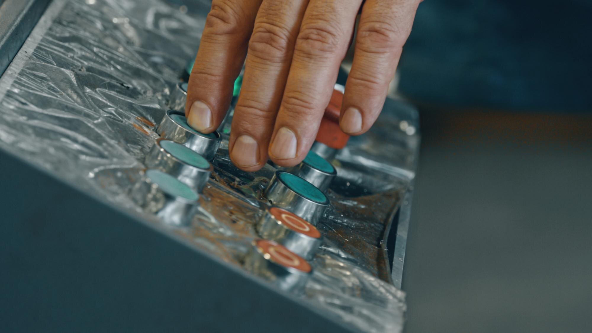 Precision cutting that pays for itself: minimise plastic waste and costs 1 factory worker operating machinery pushing buttons 35a144f2b4dac576d1f6