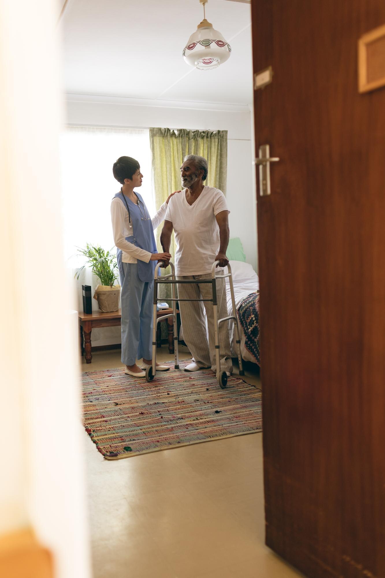 female nurse talking with senior man while walking 64a5e67f33d5f70438e4