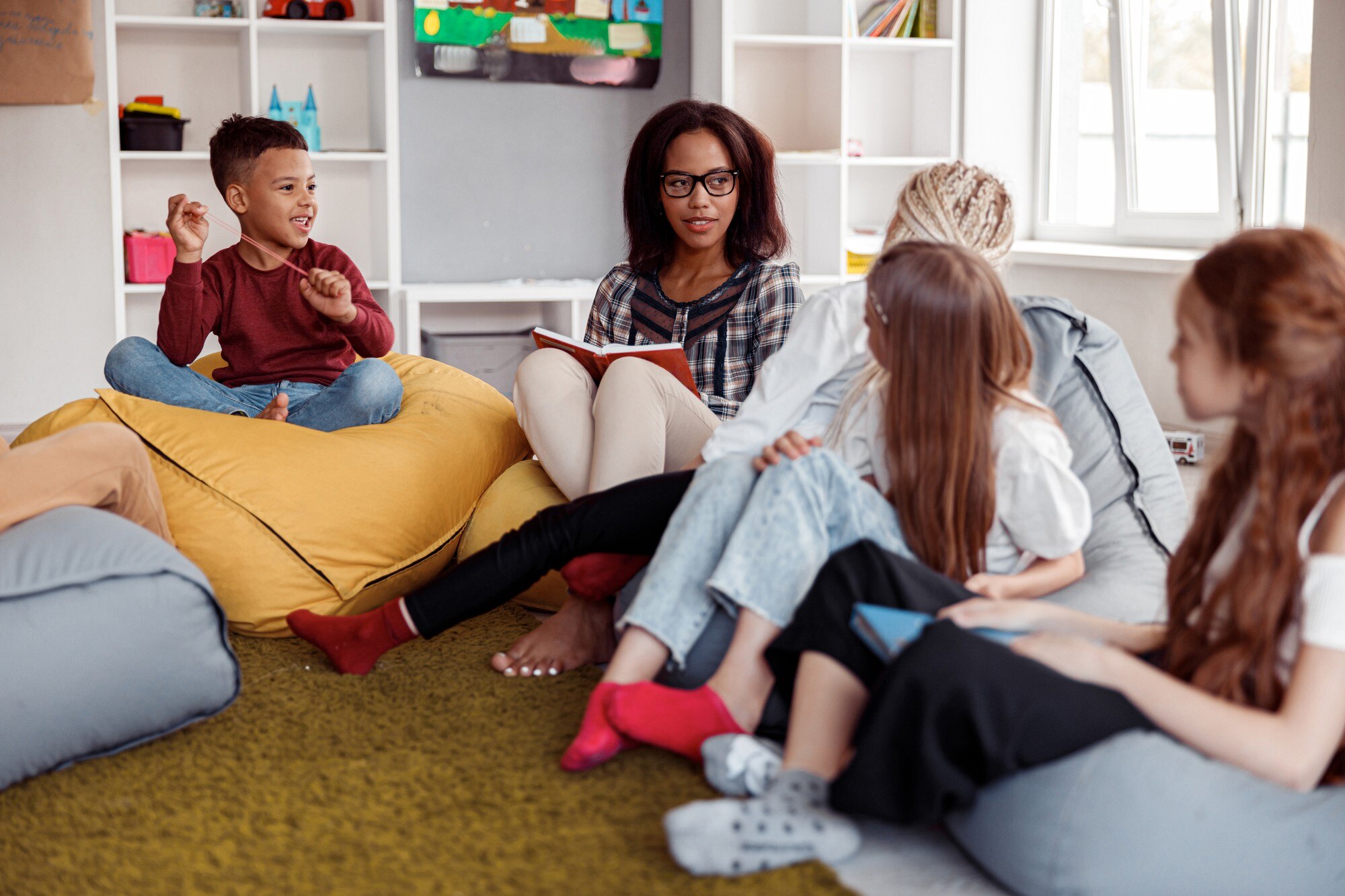 female teacher sitting on a pouf and reading for s 060ade6321d25c140435