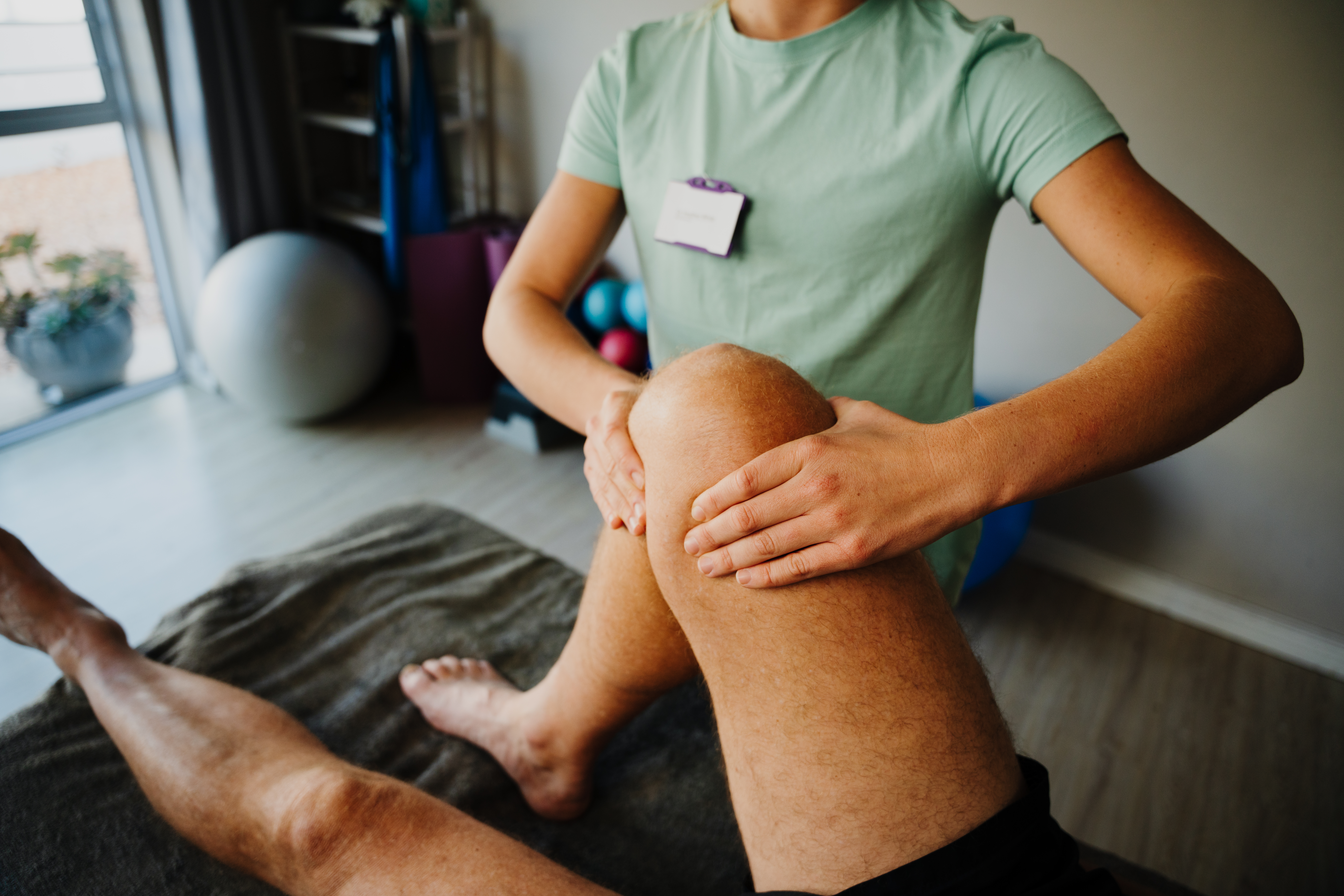 female therapist treating injured knee of male ath f1b8f05845aee0ab57ef