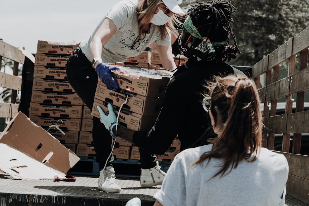 Picture of community members removing boxes of food from the back of a truck.
