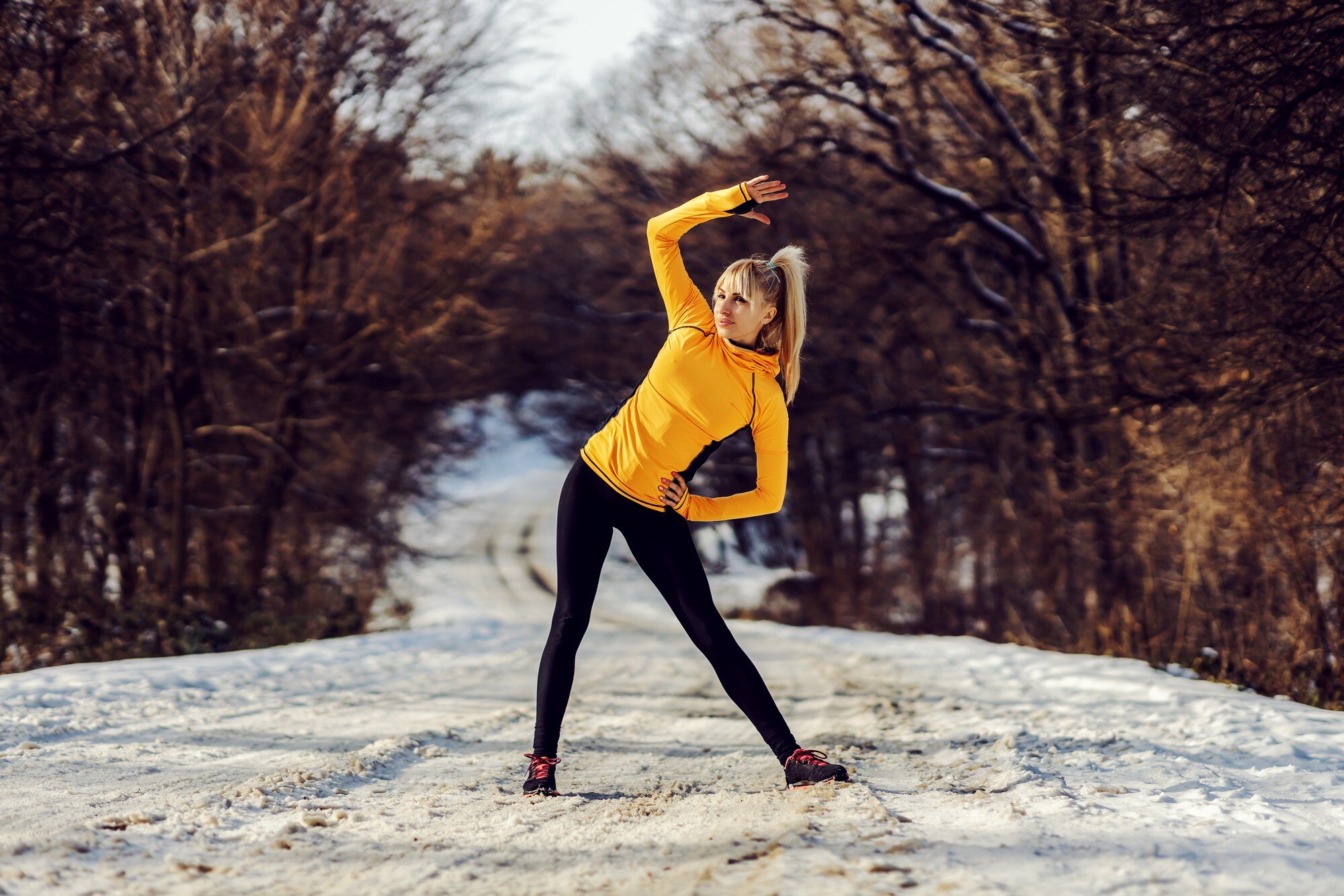 fit sportswoman standing on snowy path in nature a c79263bcb4fe44604804