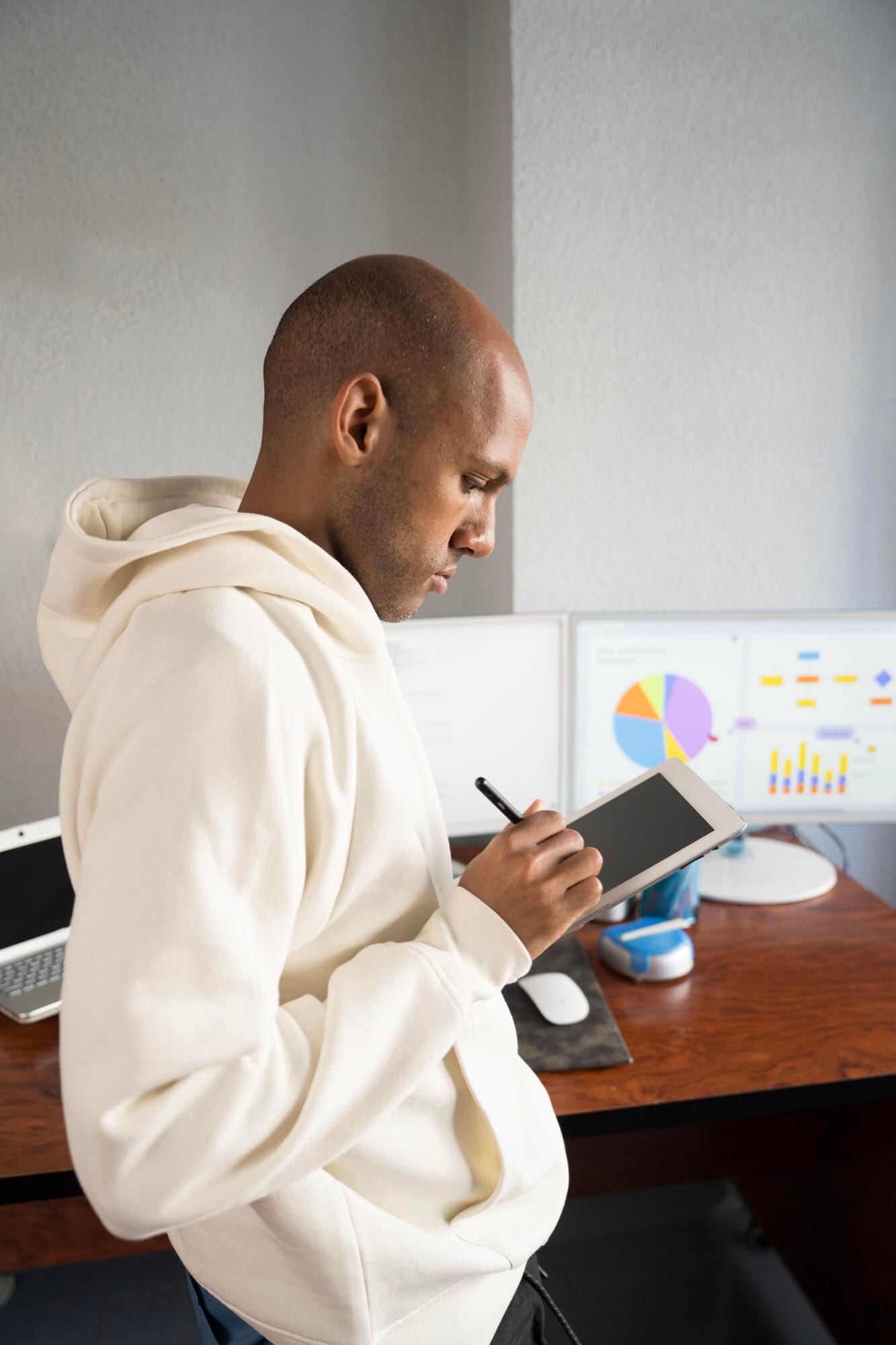 focused employee taking notes on tablet with chart 971a40655850de66d06c