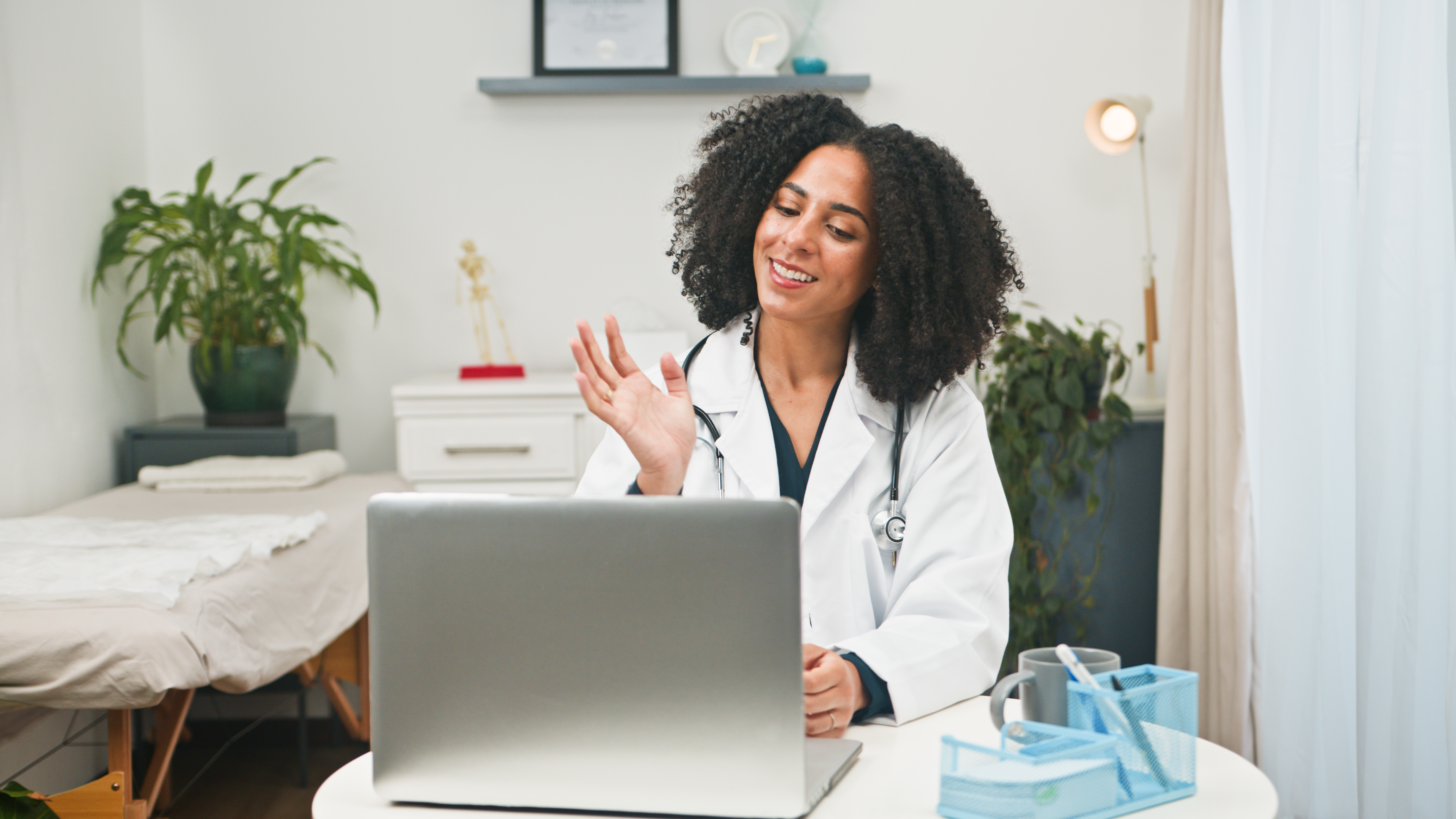 friendly female doctor waving hello during telemed d5aae10c405a70de5b6b