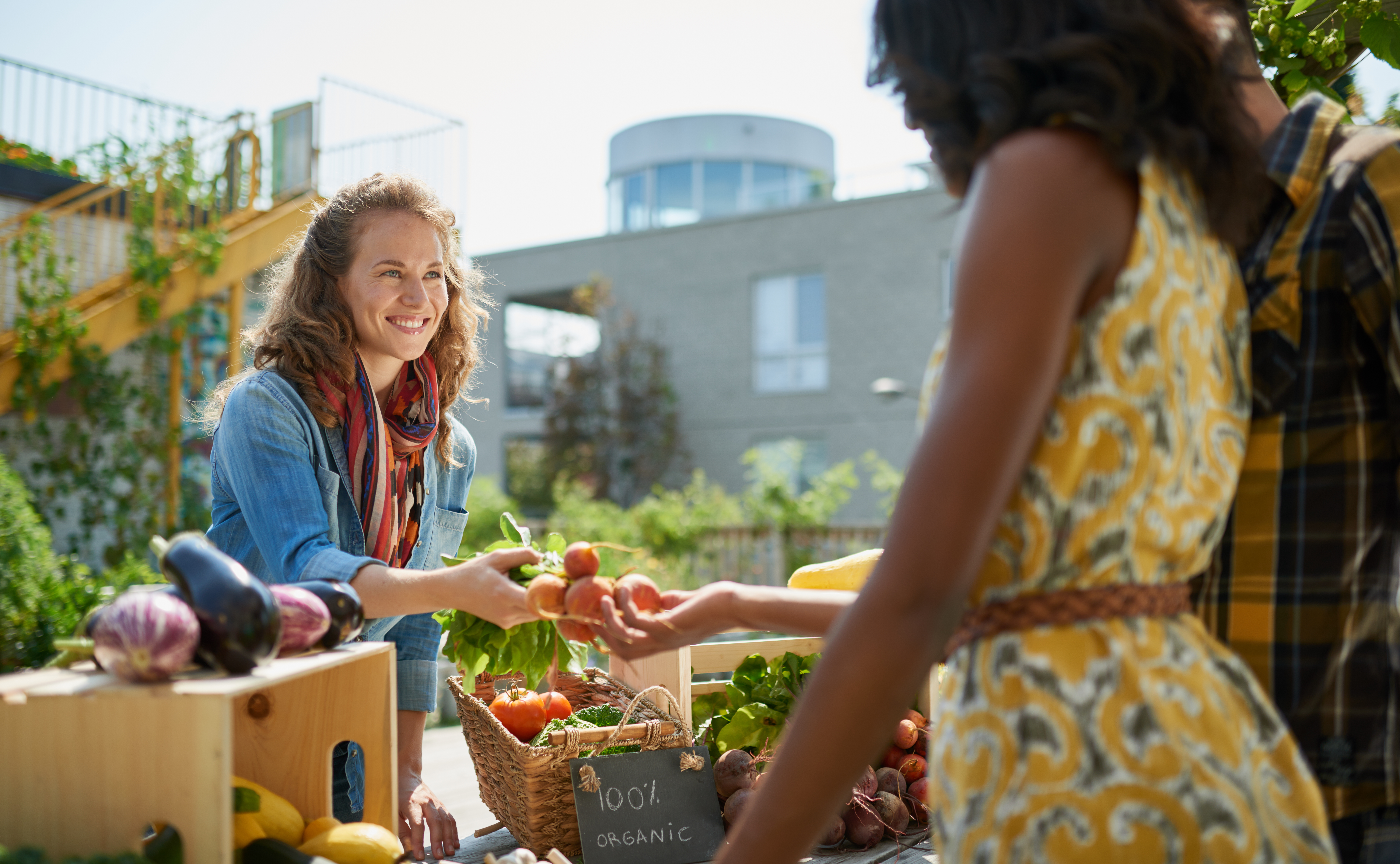 friendly woman tending an organic vegetable stall 63a51c558078803a64e2