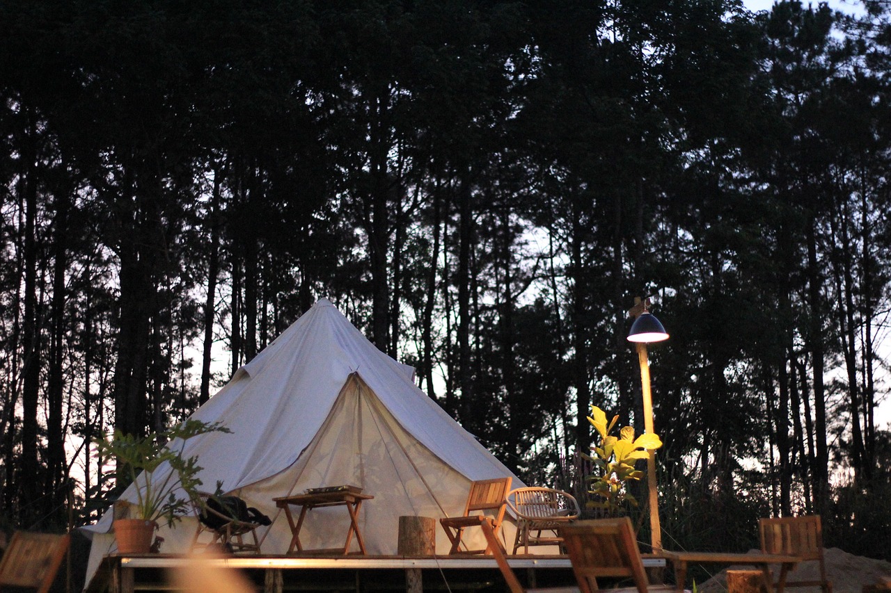 A cozy glamping tent nestled in a serene wooded setting at dusk, perfect for a peaceful cabin retreat near Austin.