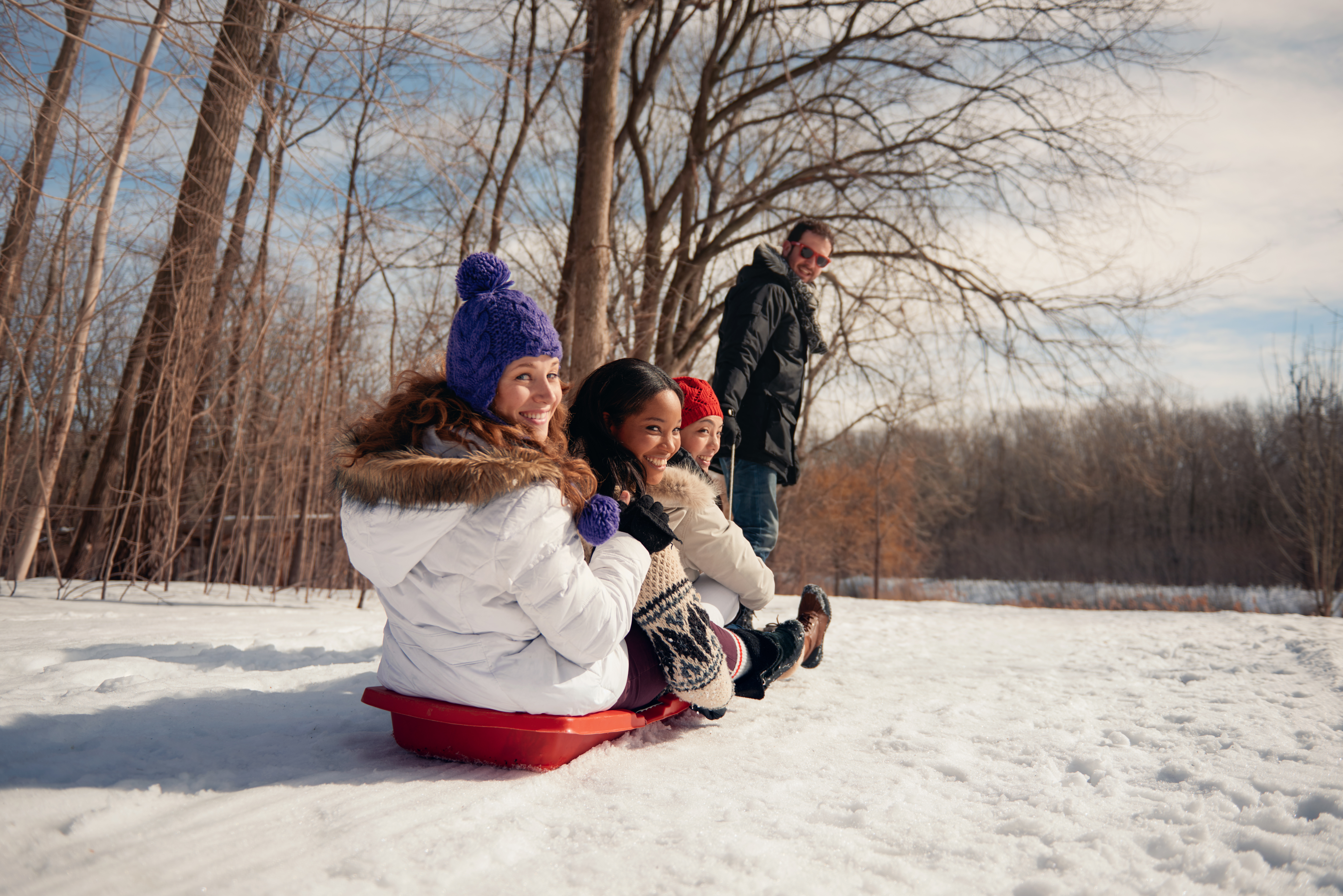 group of friends enjoying pulling a sled in the sn 6cd3c624b598cf530a66