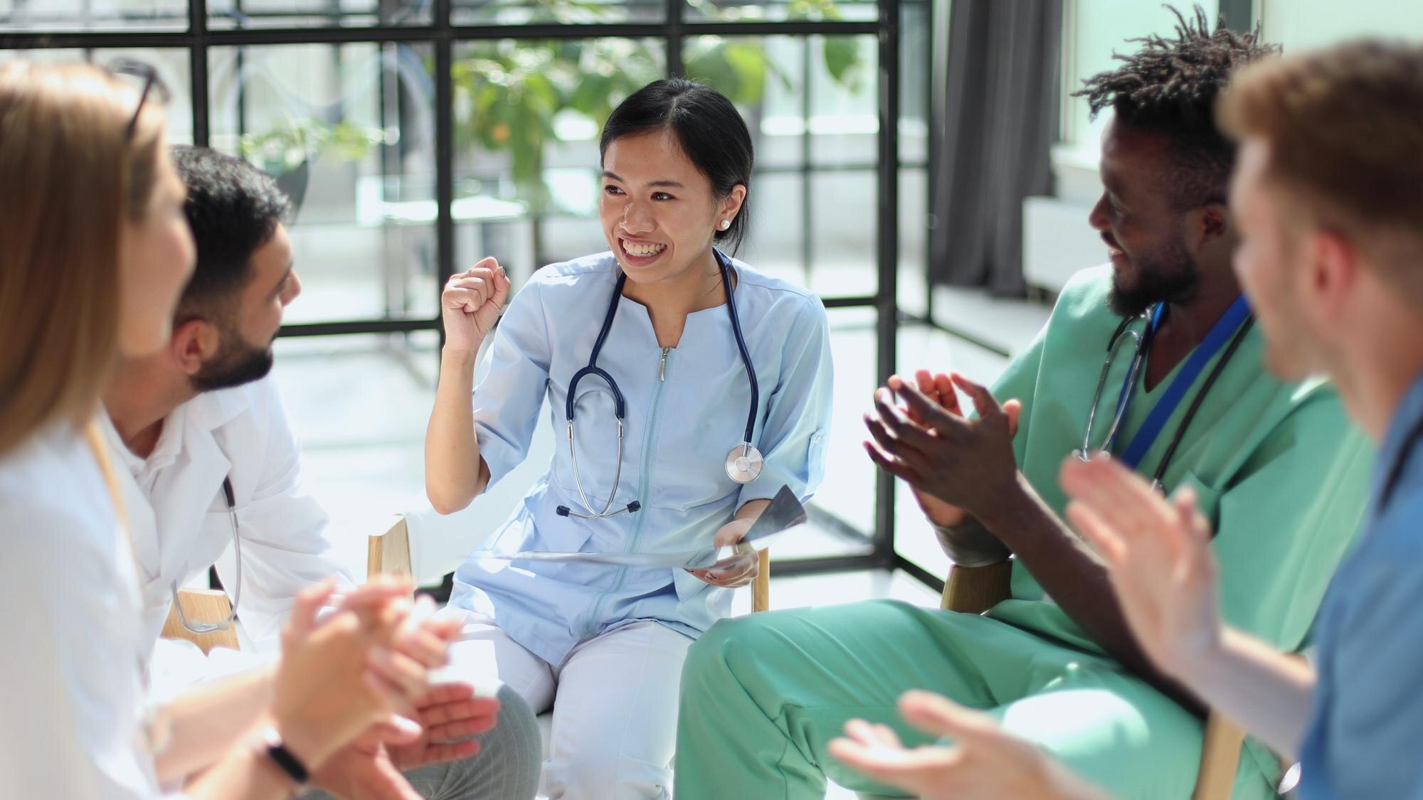 Mastering Oet Listening: Leverage Real-World Healthcare Conversations To Boost Your Skills 1 image of a group of healthcare workers in a conversation. An illustrative image for healthcare conversation and OET Preparatoin.