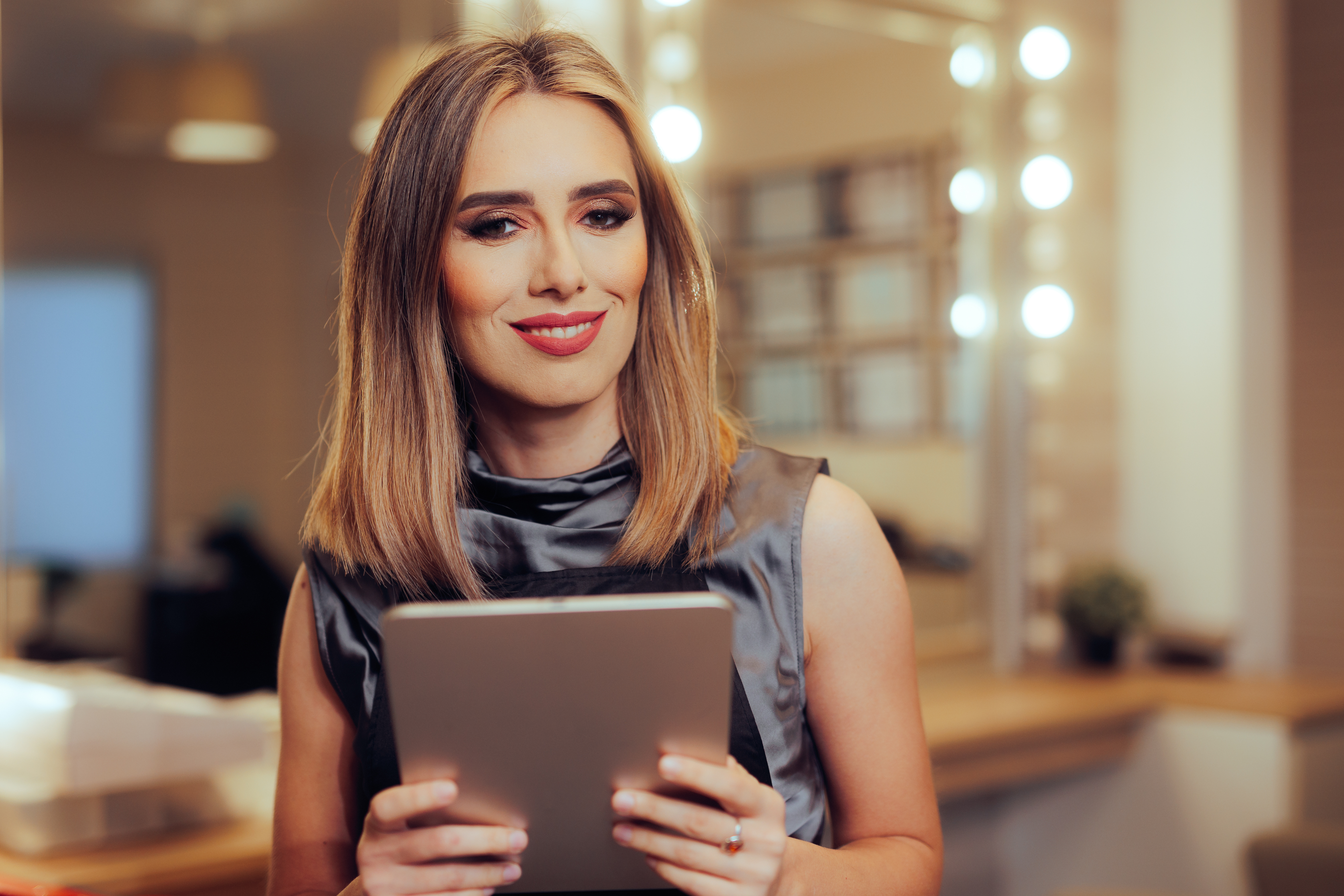 hair salon worker holding a pc tablet making appoi 3f9abf8b208c02b62b5c Liberating Beauty Professionals: The Impact of Contract-Free Booking Models