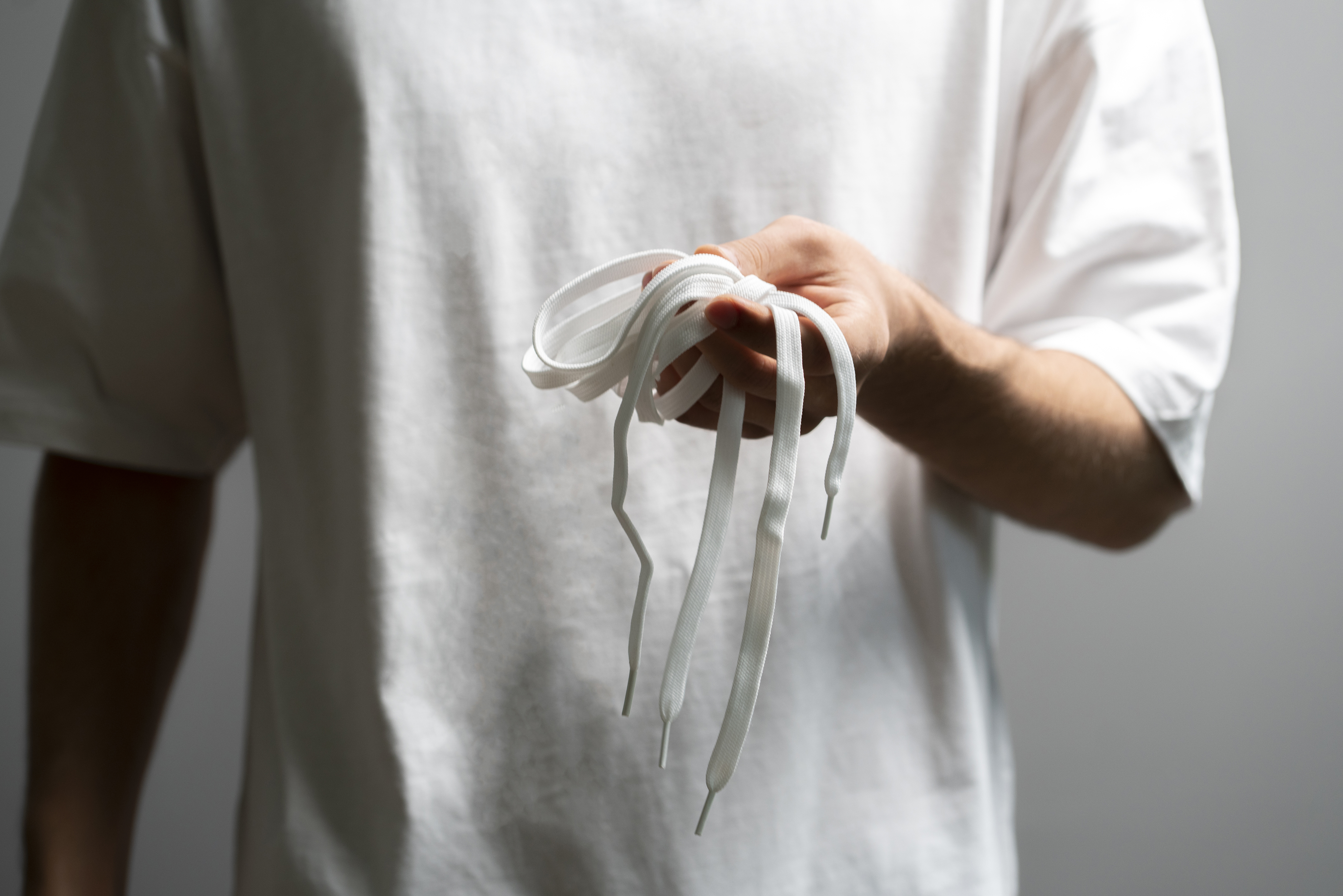 Buy cheap, buy twice: The real cost of poor‑quality plastics in fabrication 3 hand holding pair of white shoelaces new shoes st 4b5cddeaf56d825c3972
