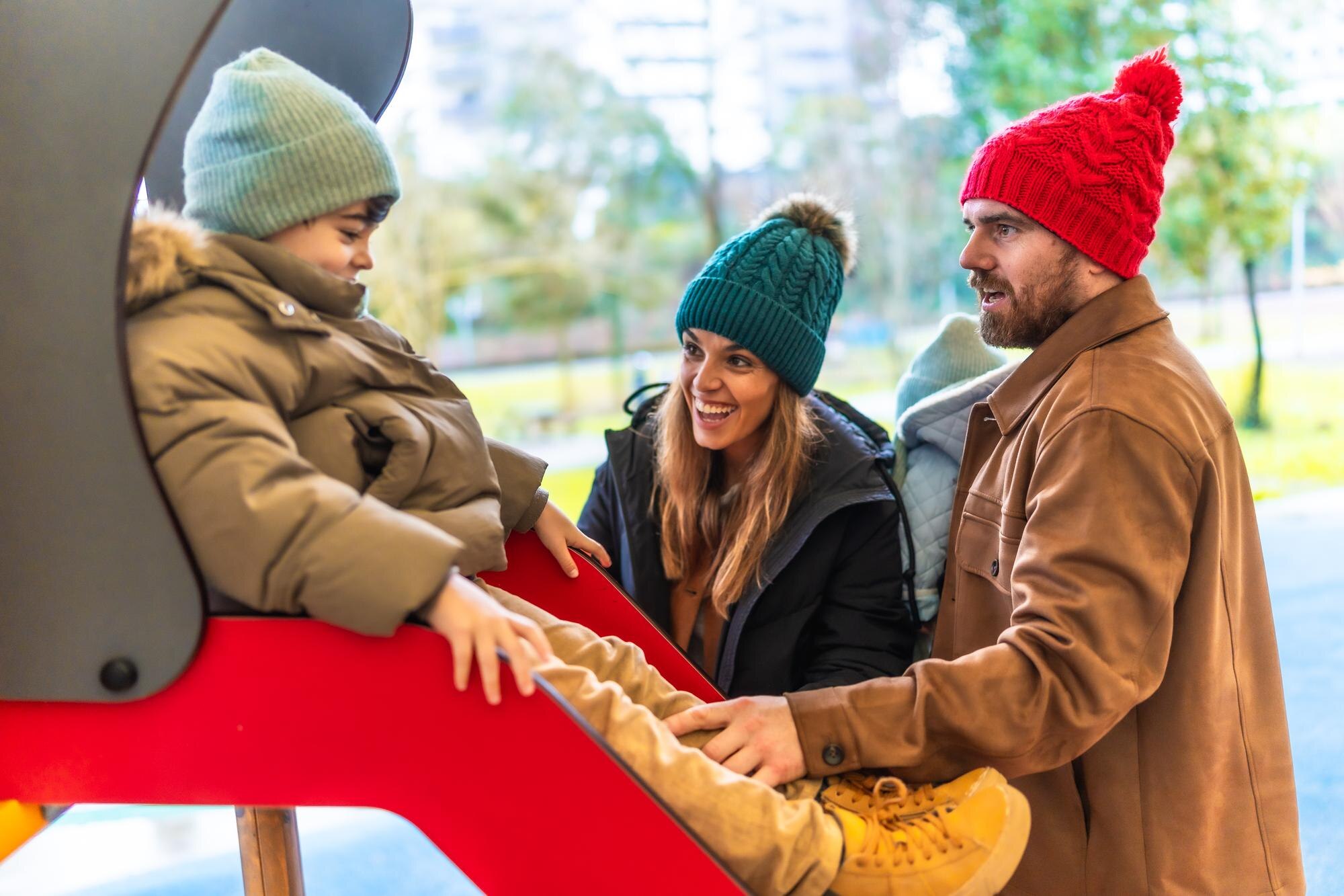 happy family having fun on slide at playground in a6ccf3d60172d119f844