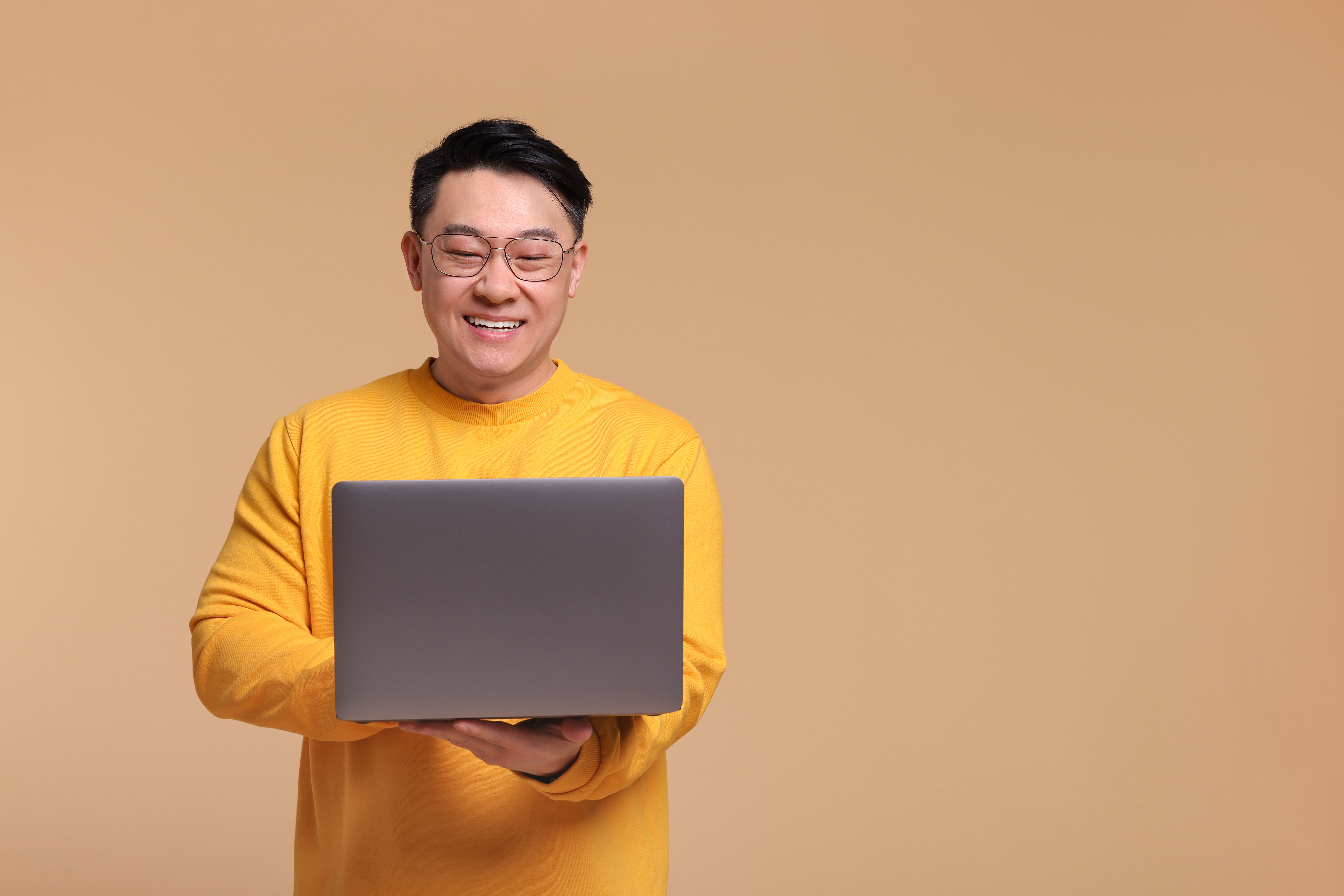 happy man with laptop on beige background space f 165d7d5ec0ba3a92c15a
