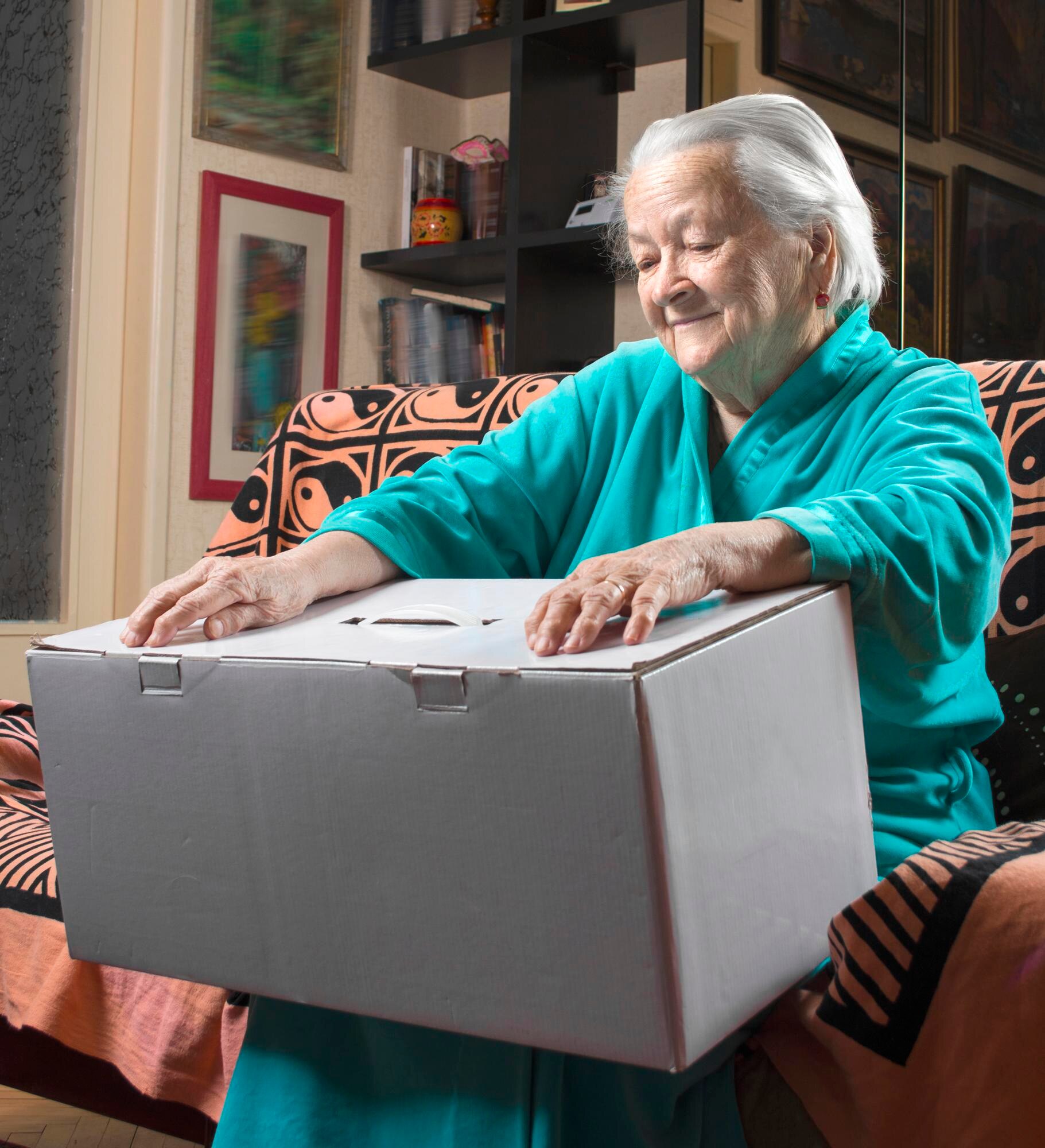 happy old woman holding a large cardboard box at h 4ffa39a6c522777e7755