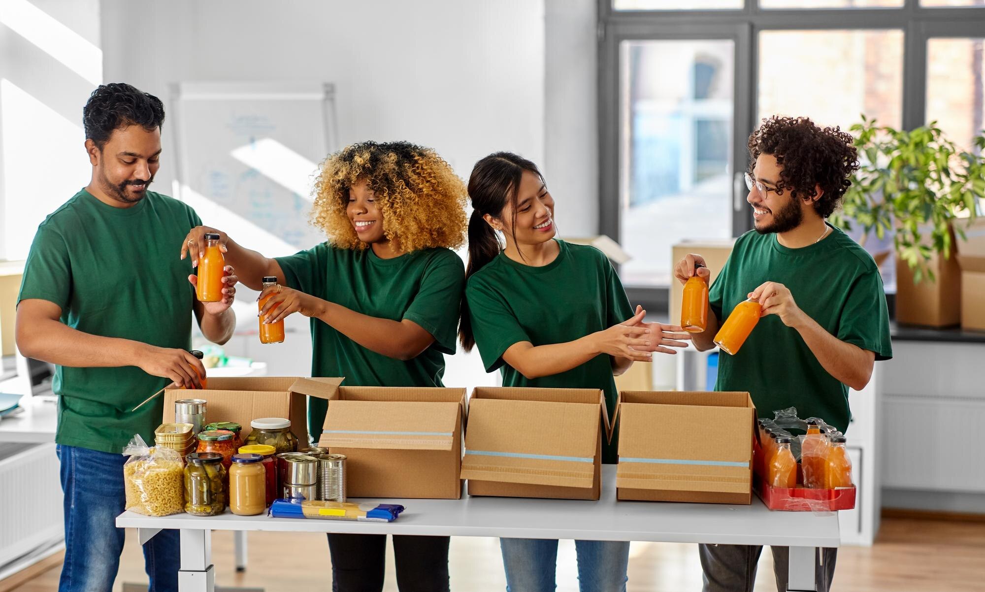 happy volunteers packing food in donation boxes 5af8026024605b1374cc