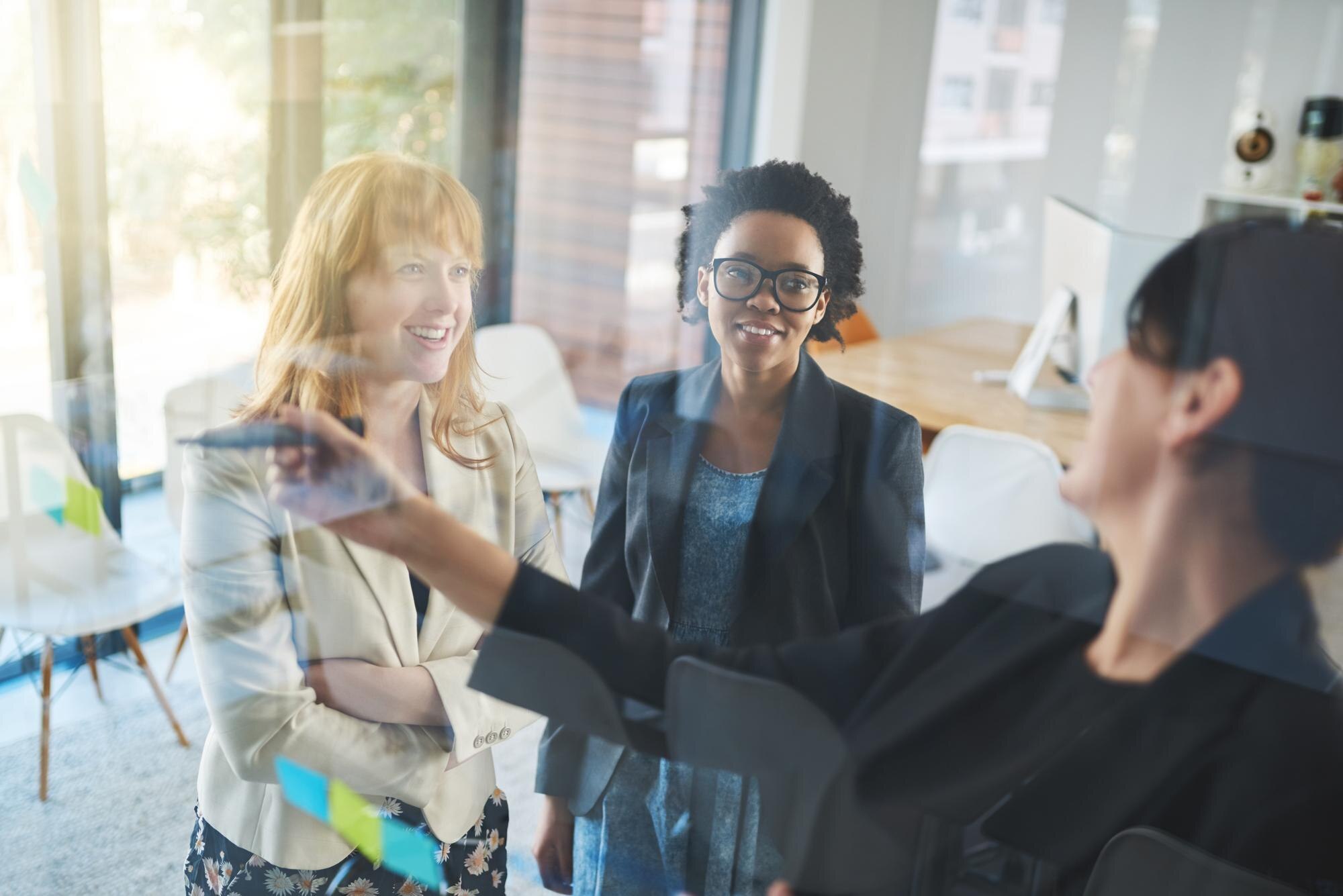 happy women teamwork and brainstorming notes on wi c0f25192f3308450878a