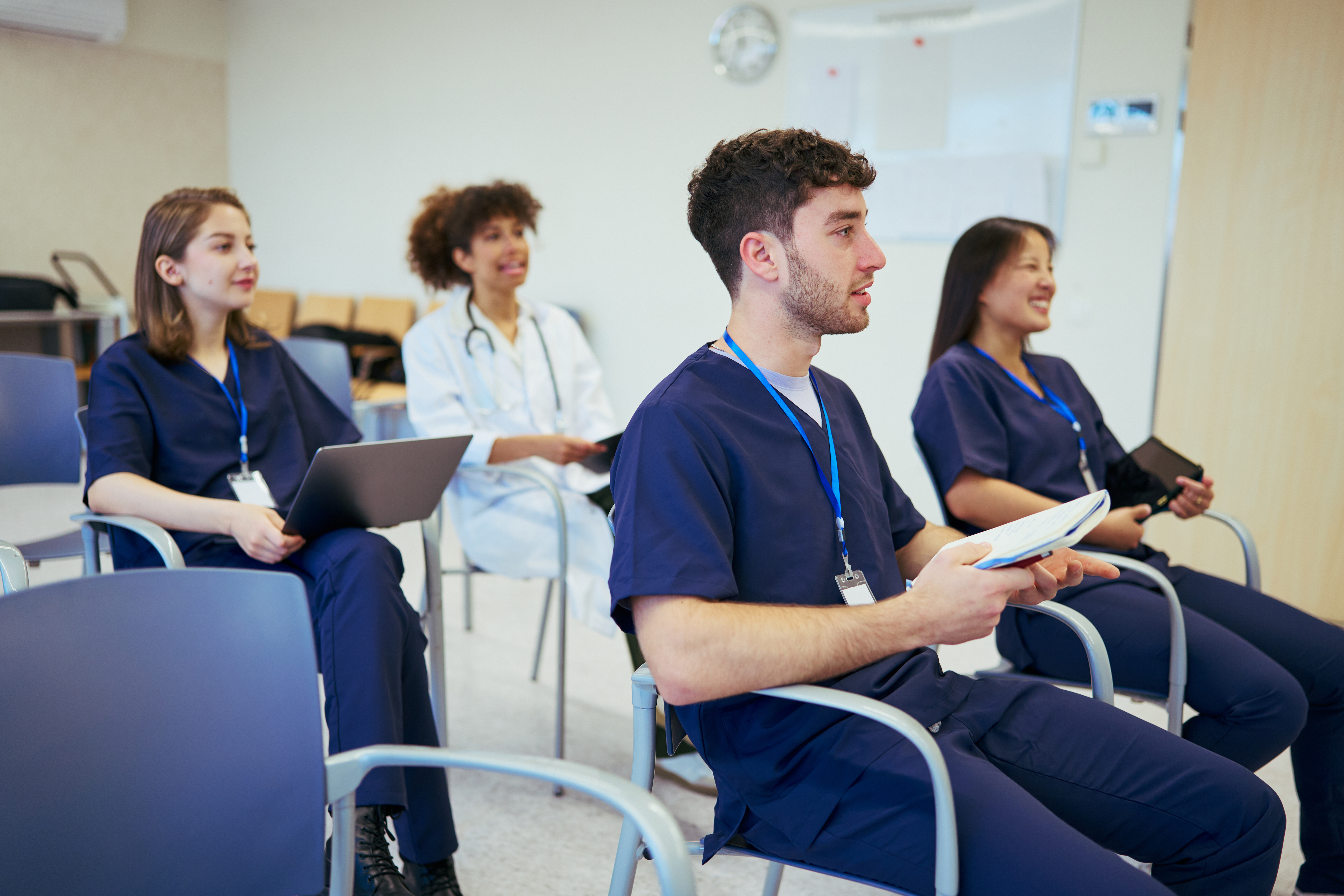 Unlock Your Global Medical Career: The Benefits Of Expert-Led Oet Preparation For International Medical Graduates 1 image of a group of medical workers in a classroom listening to a lecturer—illustrating article on OET and medical careers—#The best OET Preparation course