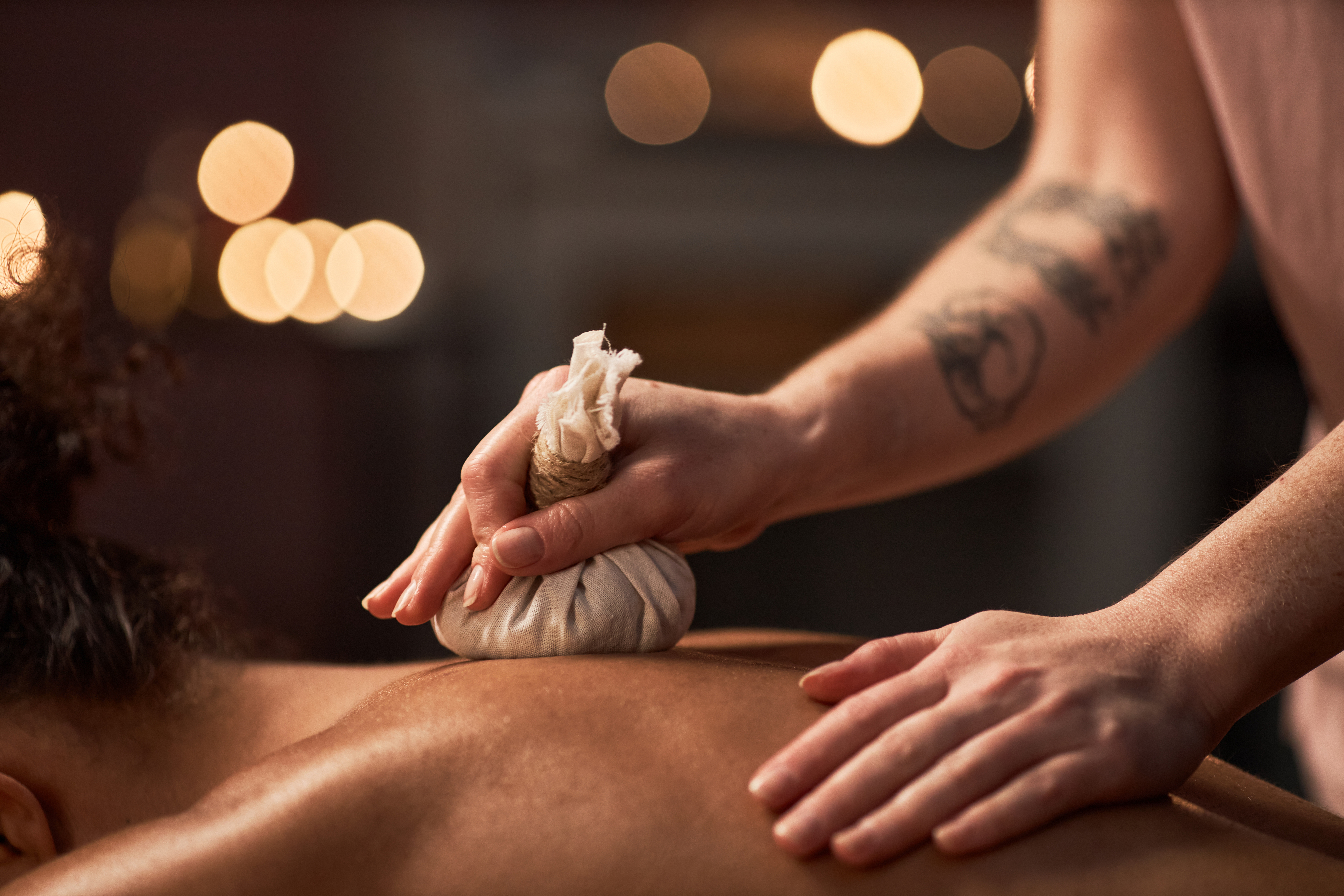 Herbal compress massage therapy for relaxation at a wellness spa