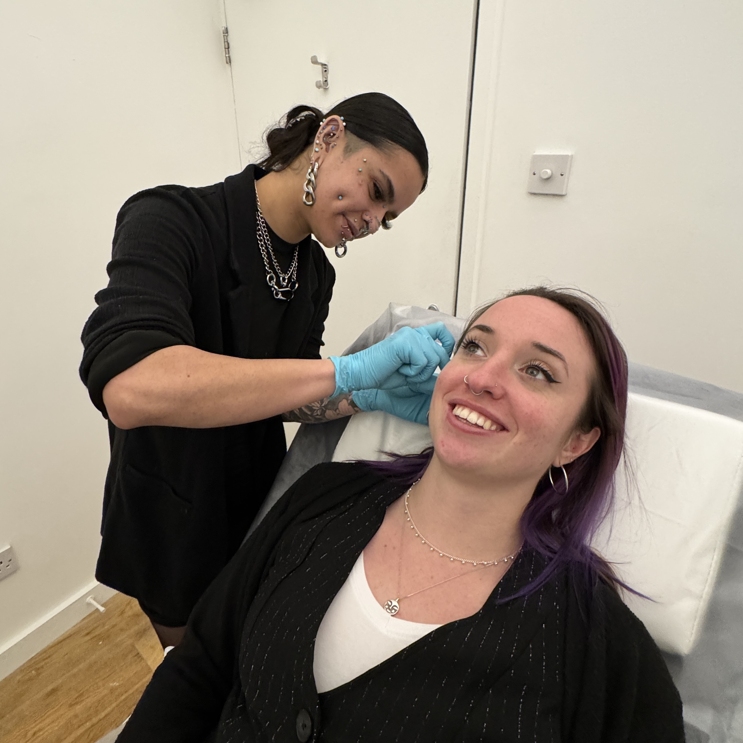 app-member-steph-performing-a-jewellery-change-on-a-client-isha-body-jewellery-dorset-body-piercing-studio