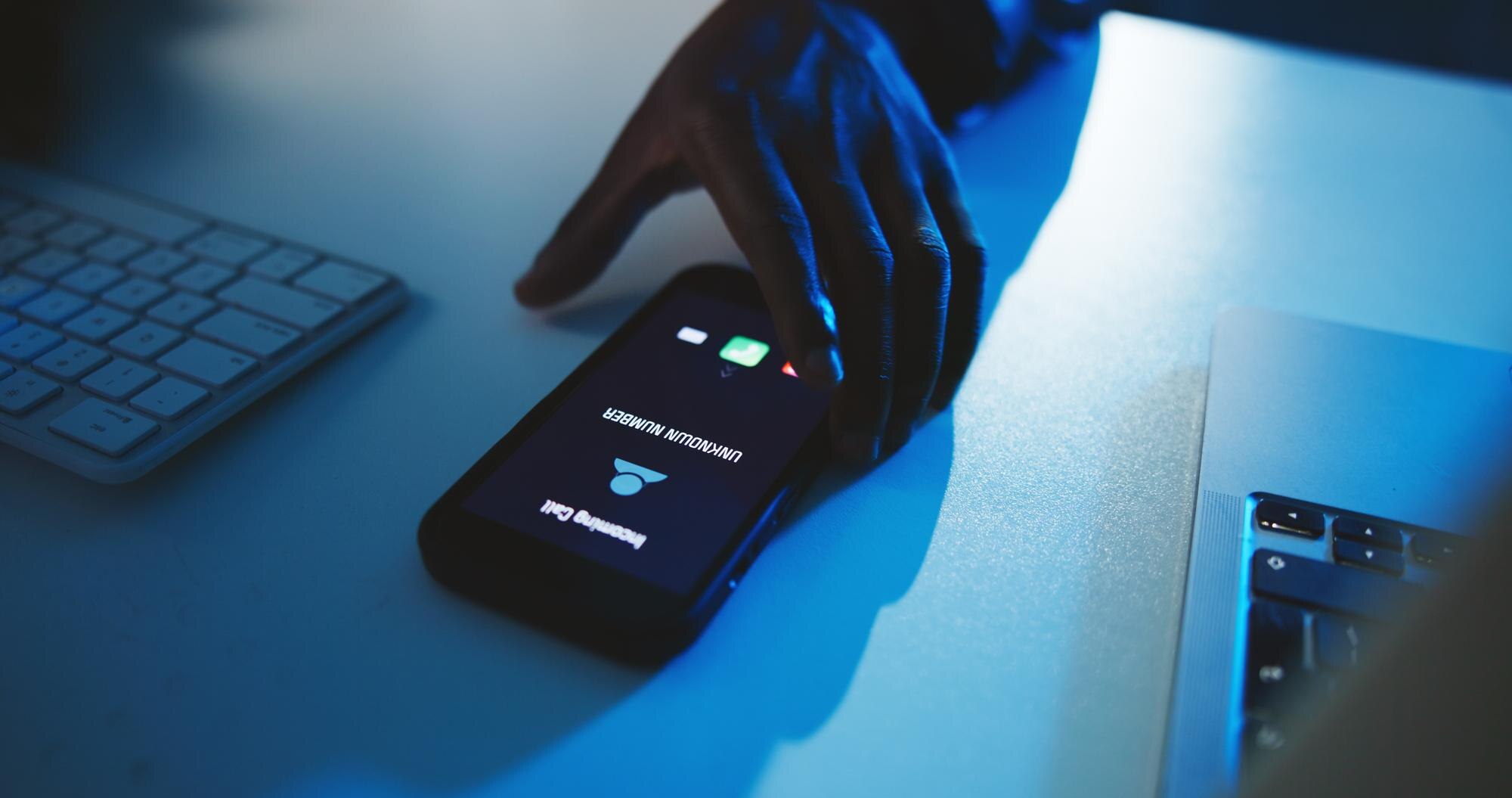 Person holding phone to illustrate spear phishing protection
