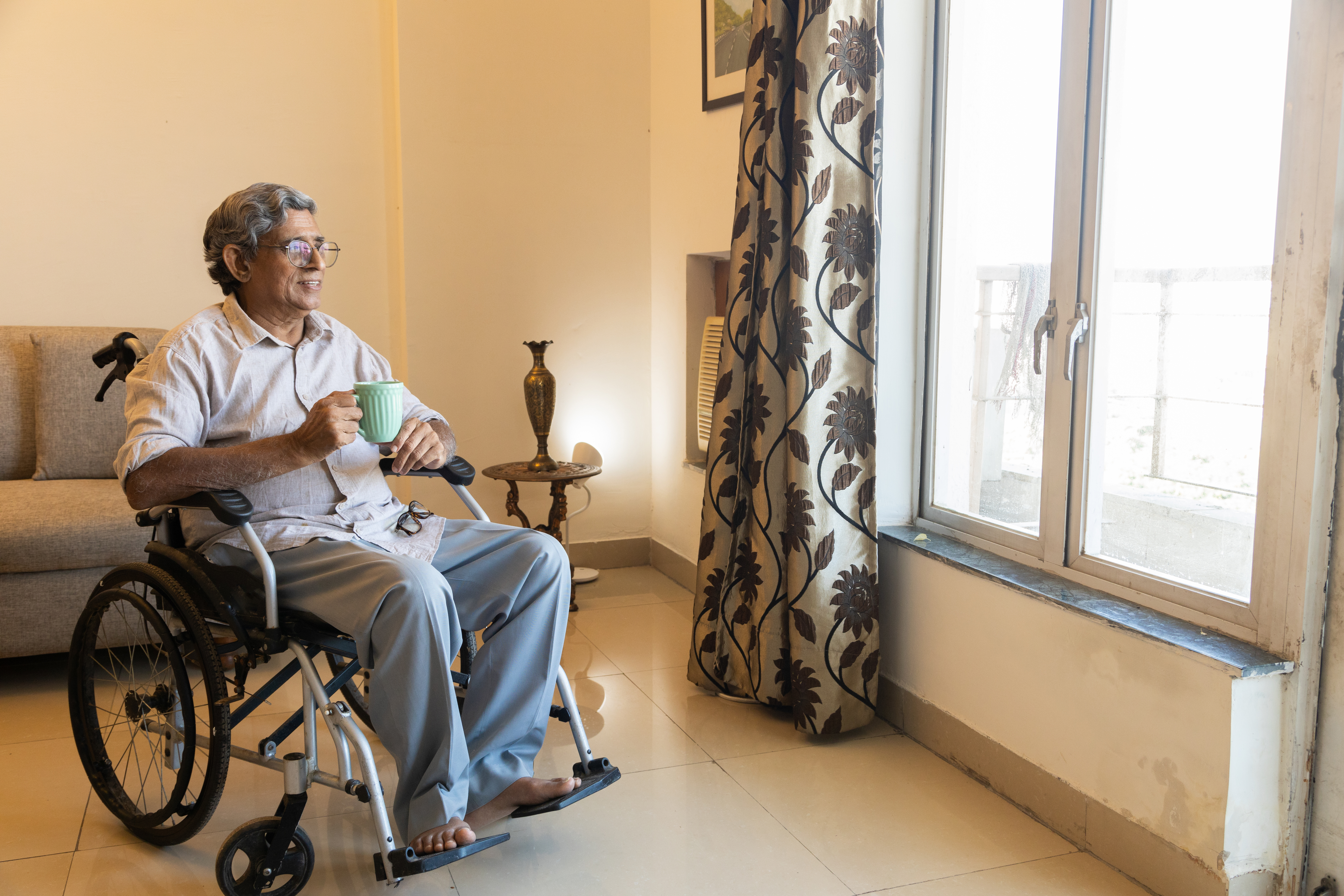 indian senior disabled man holding a cup of coffee 4310039be10d4690fdaa