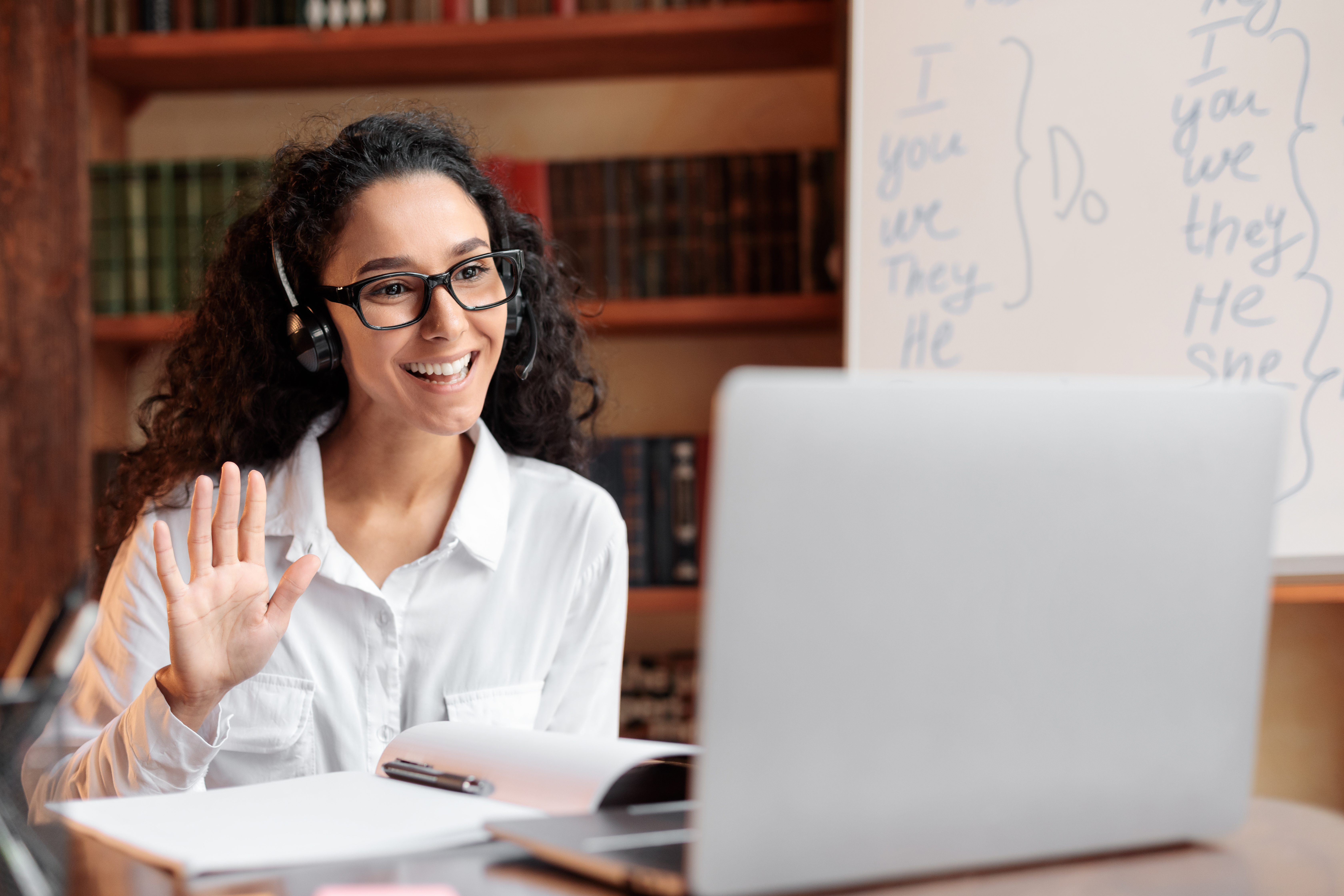 Lady Sitting At Desk Using Computer And Waving To 47d131a31684bac64b1b