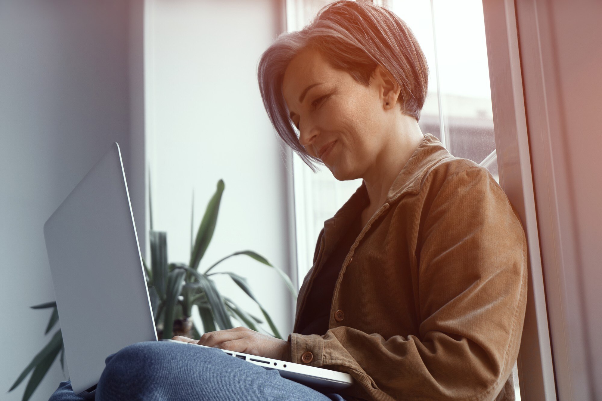 low angle mature woman smile looking at laptop co 83abd2c3f945e6f17e47