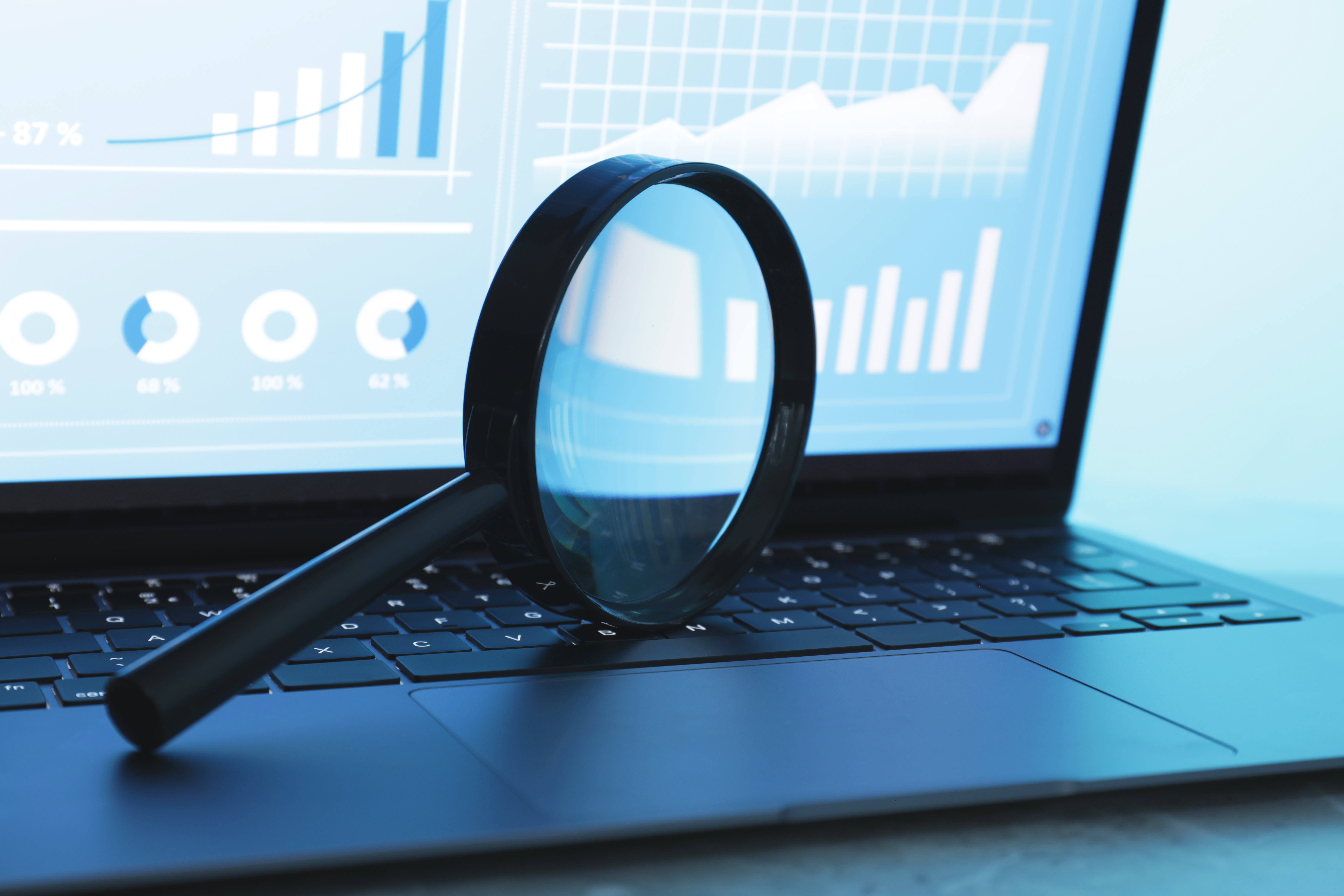 Magnifying glass analysing website analytics to diagnose why a Website Is Underperforming in search.