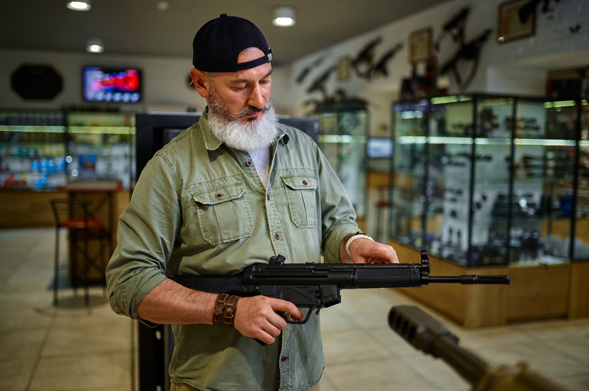 male seller holds automatic rifle in gun store we 0ace152500a47d1edaf8