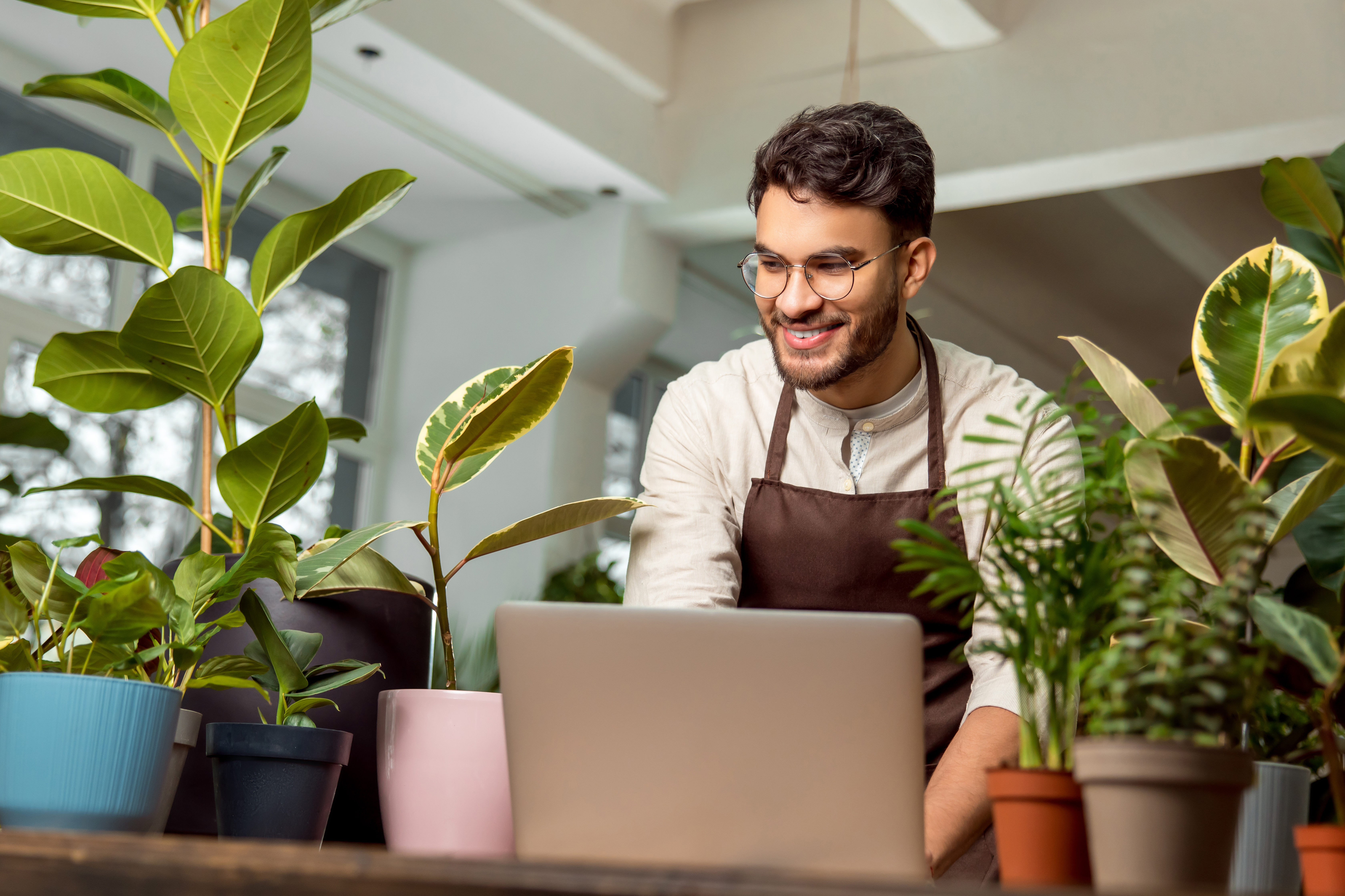 male shop assistant in the flower shop working on d2fc2085471f9c06f2fb