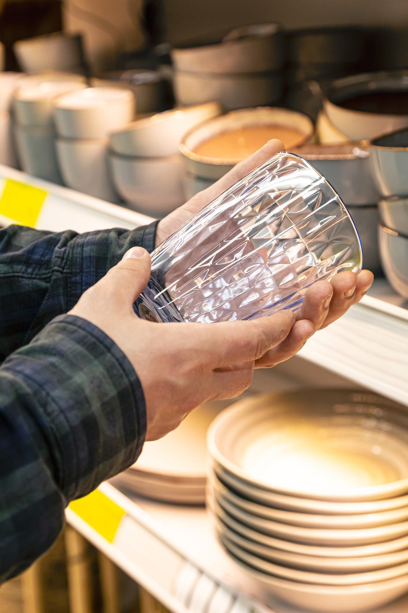 Made Here, Made Better: How Local Manufacturing Elevates Custom Plastic Products 2 man holding glass from a shelf in homeware store 67e036264bf1cc2a1342