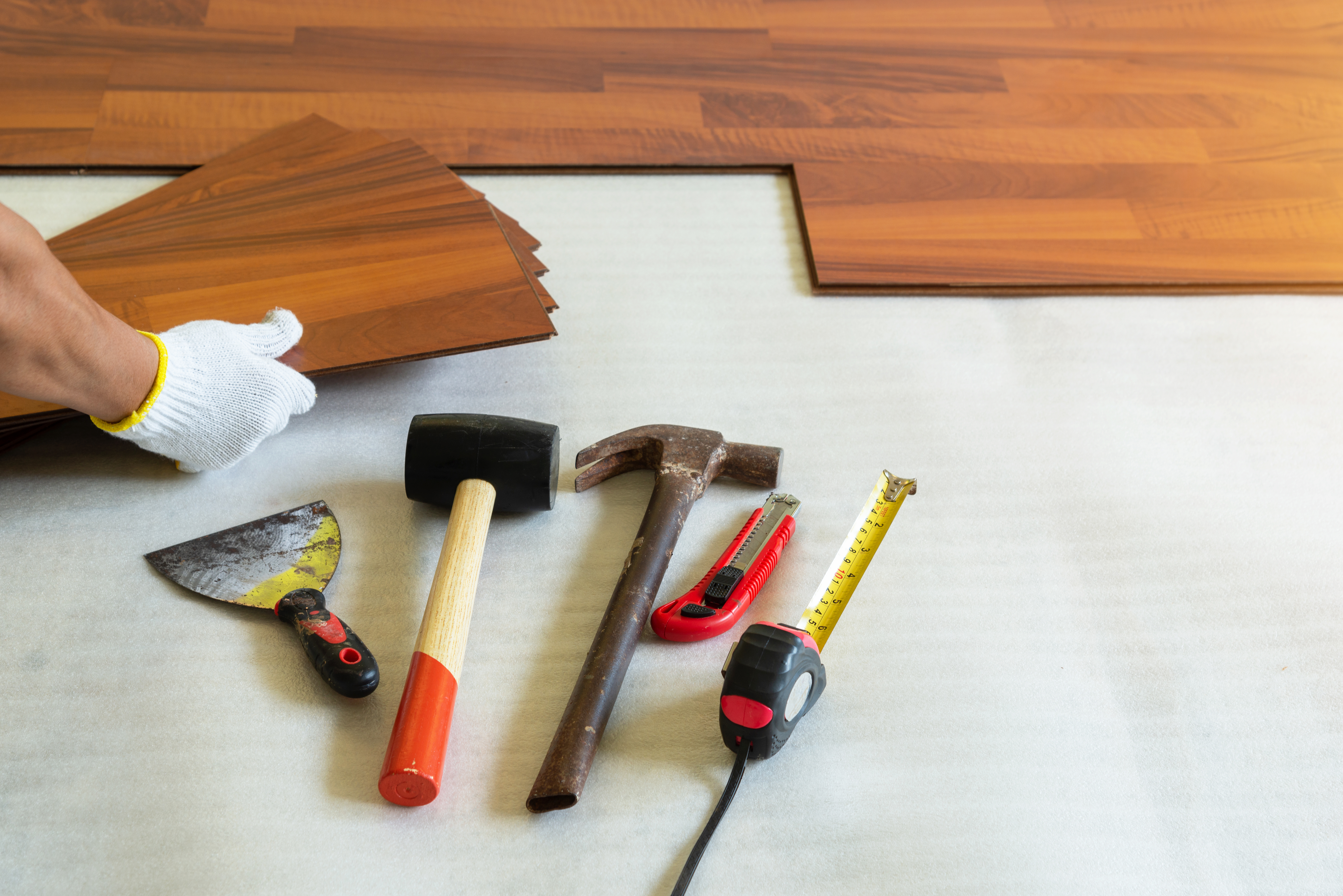 Man installing new laminated wooden floor constr 5d0e1c6471007bfe5d84