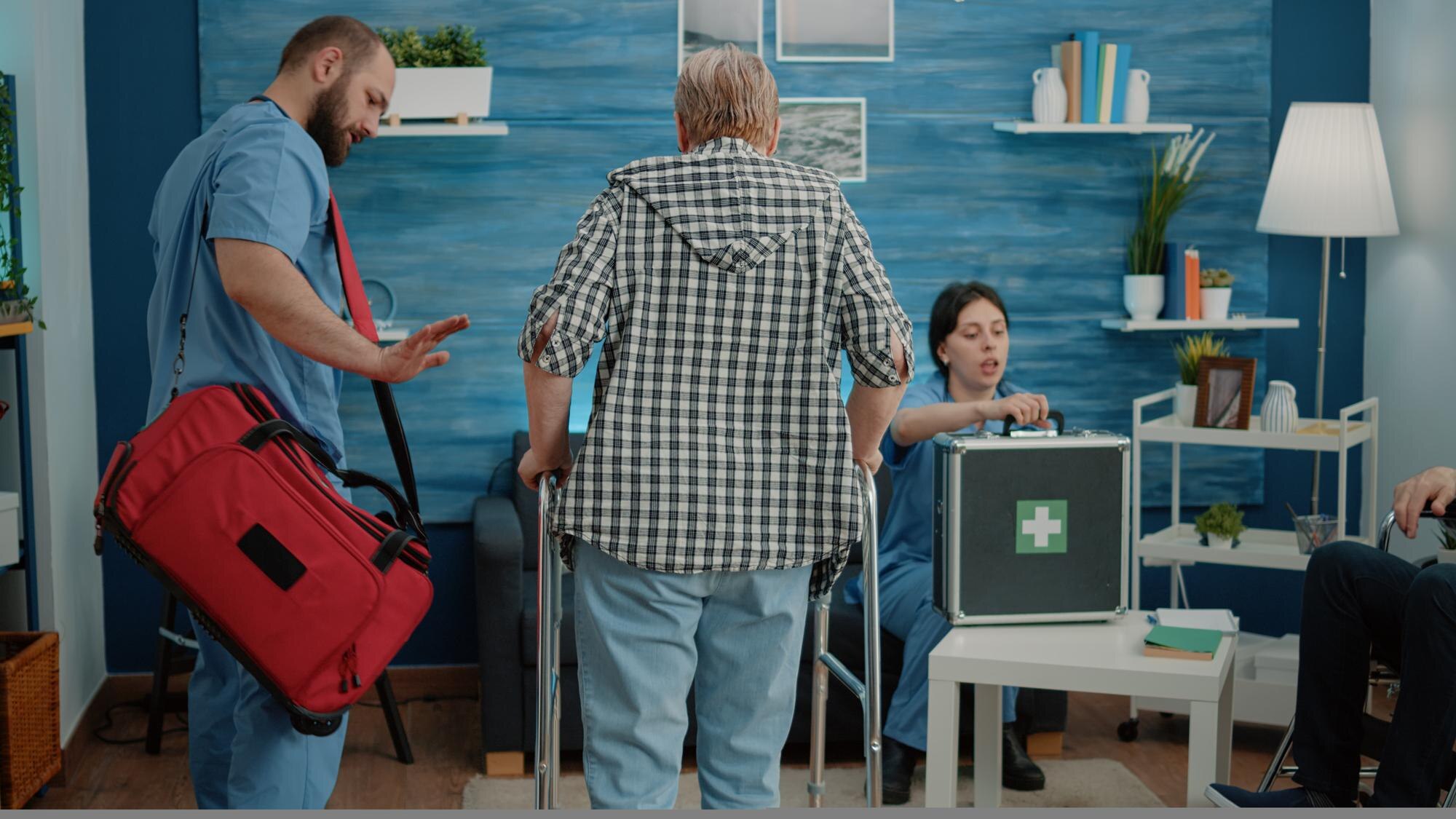 man nurse supporting senior woman using walk frame f3eb900d11176be243fe