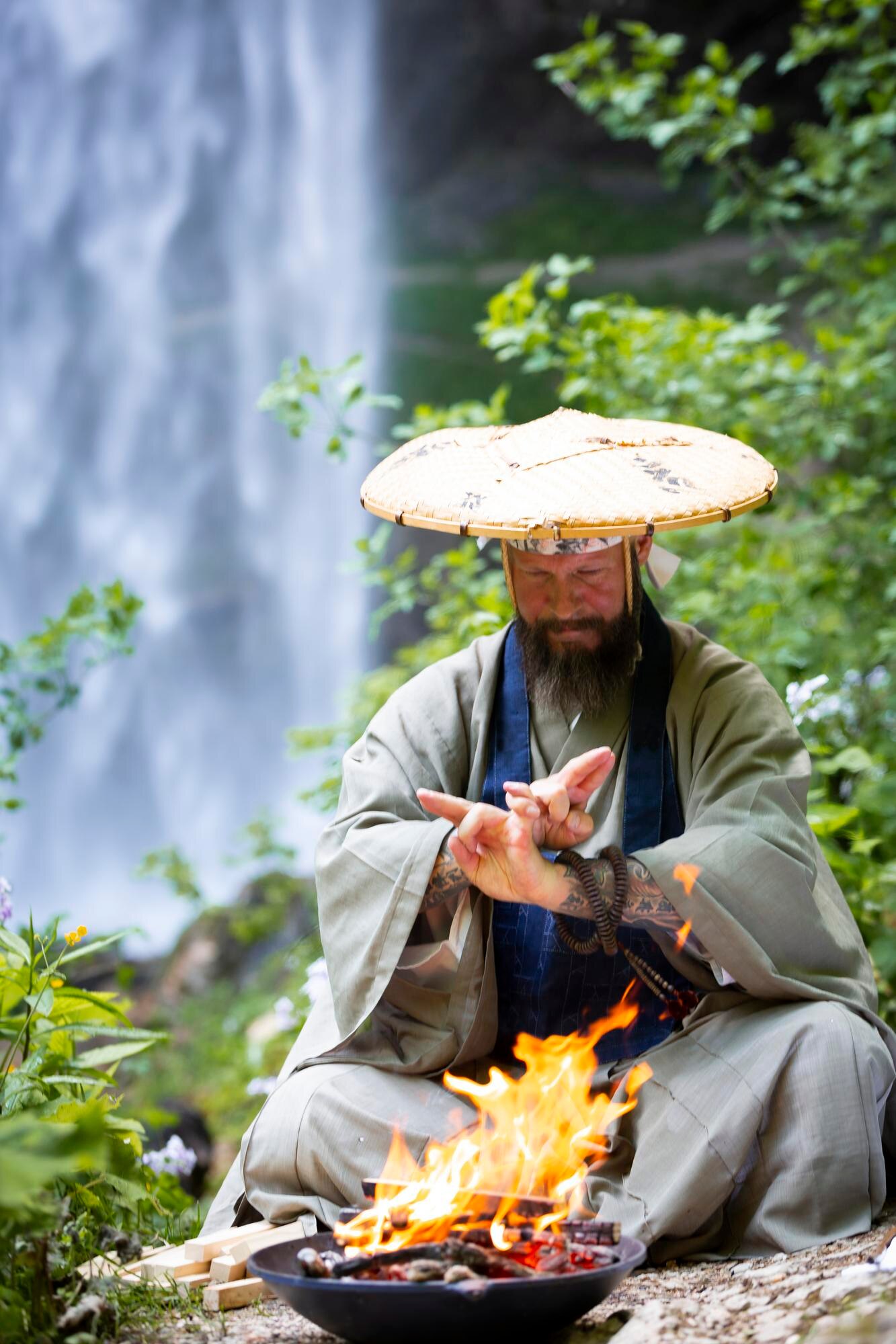 man sitting with fire pit against waterfall in for 585ad7ca43bcac5b632e