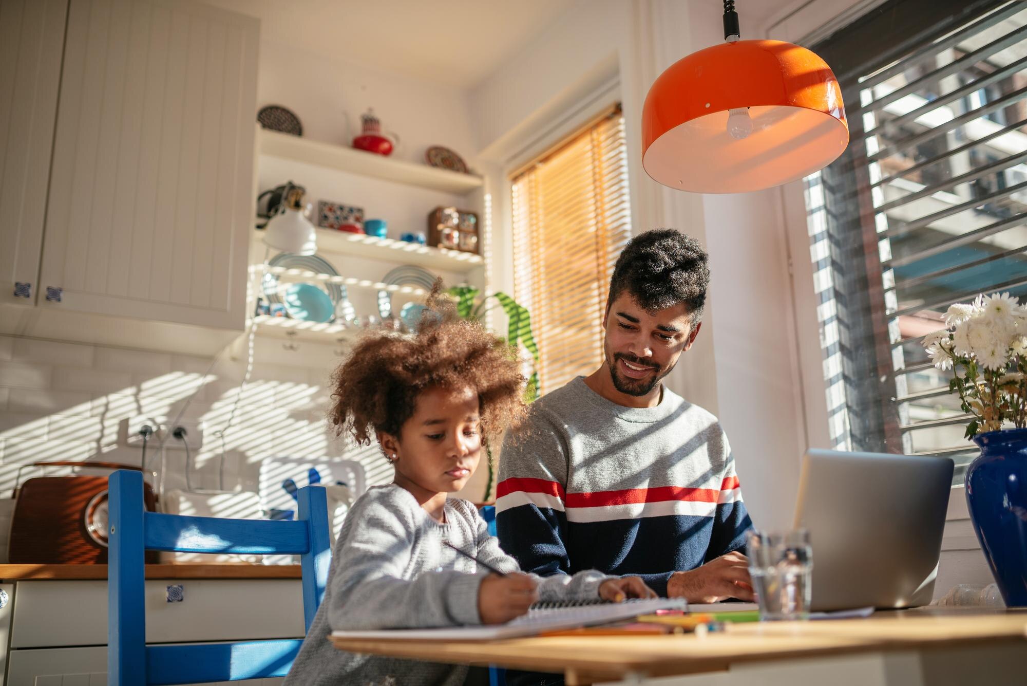 Man Working On A Computer While His Daughter Is Le 43bc309cd5a856933c62