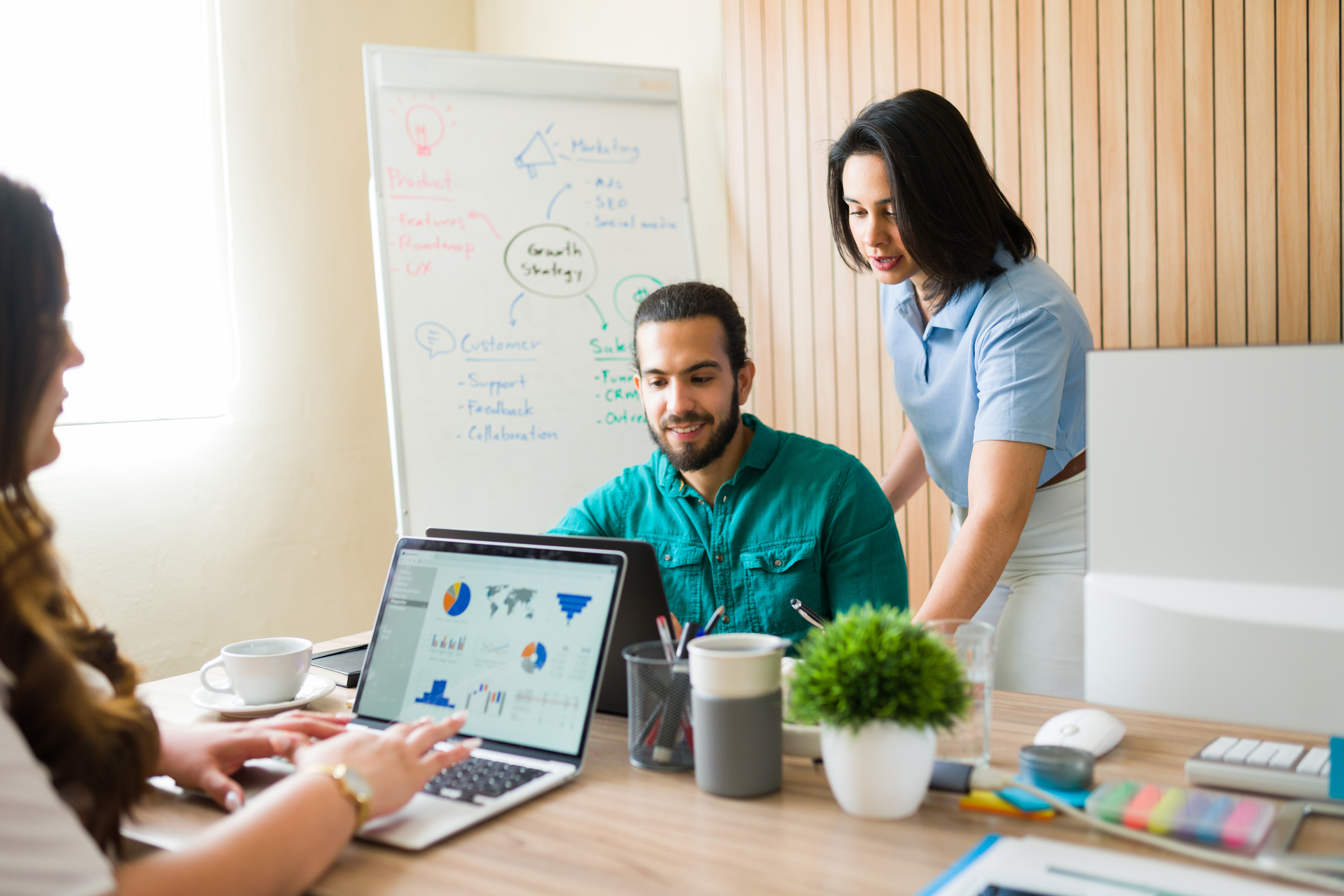 coworkers in front of a computer at a desk talking