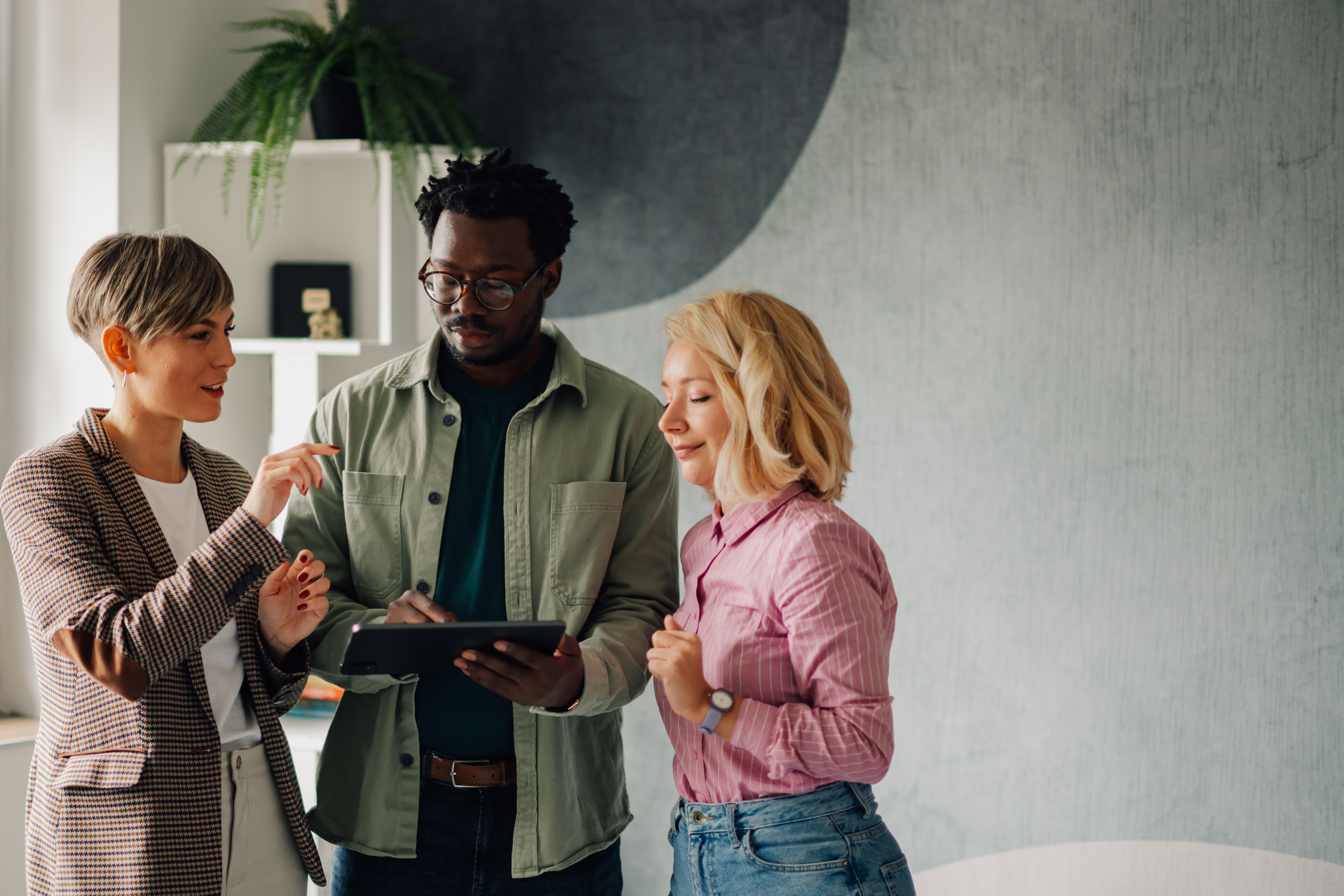 Team collaborating on a tablet, discussing video creation strategies for enhancing Google Business Profiles.