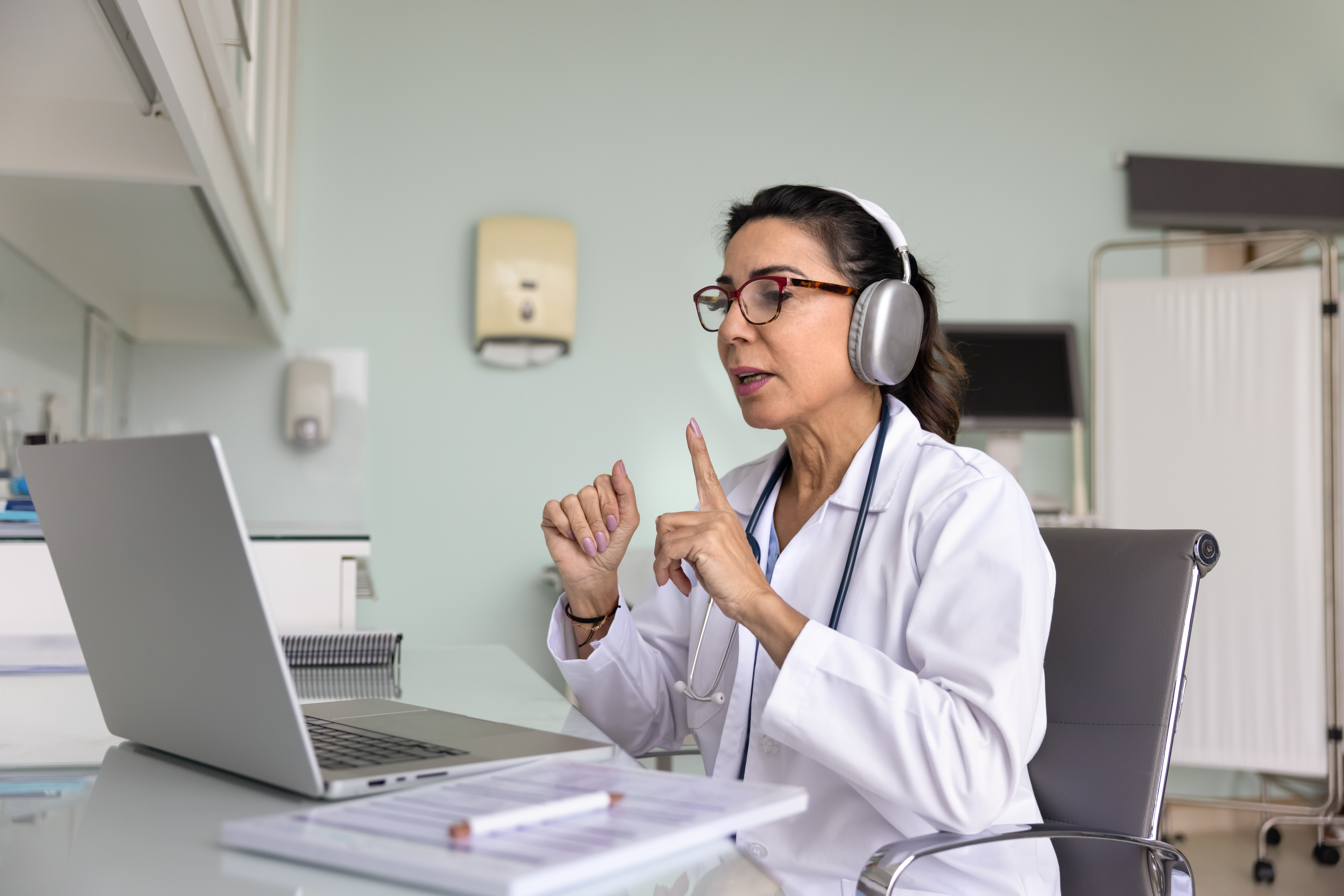 mature 60s female doctor conducts virtual consulta ce915418eed100faed7b