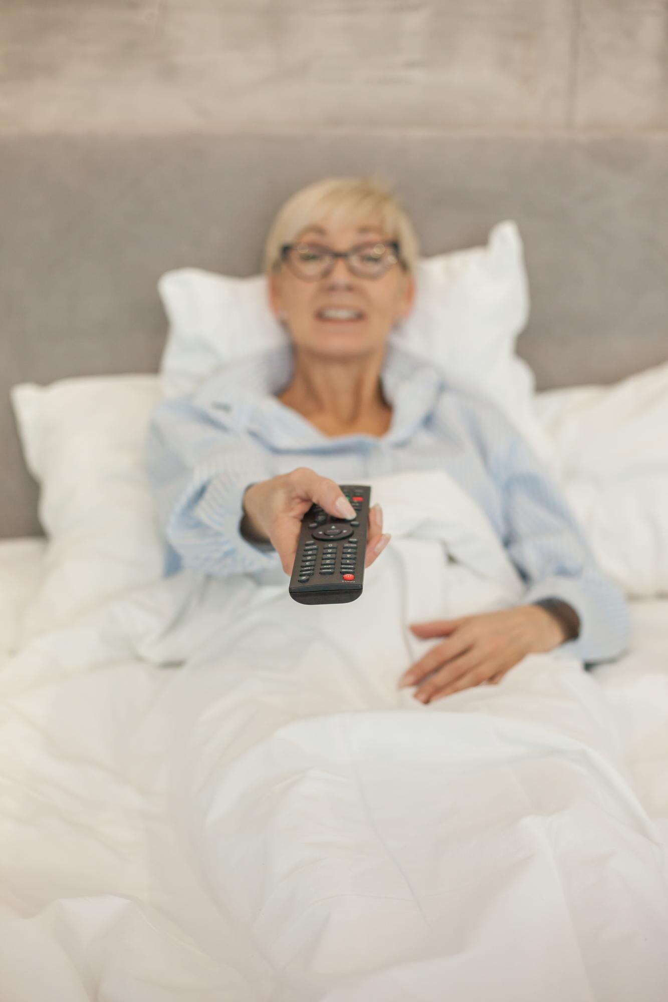 mature woman watching tv on bed 14907003d910a02f92fd