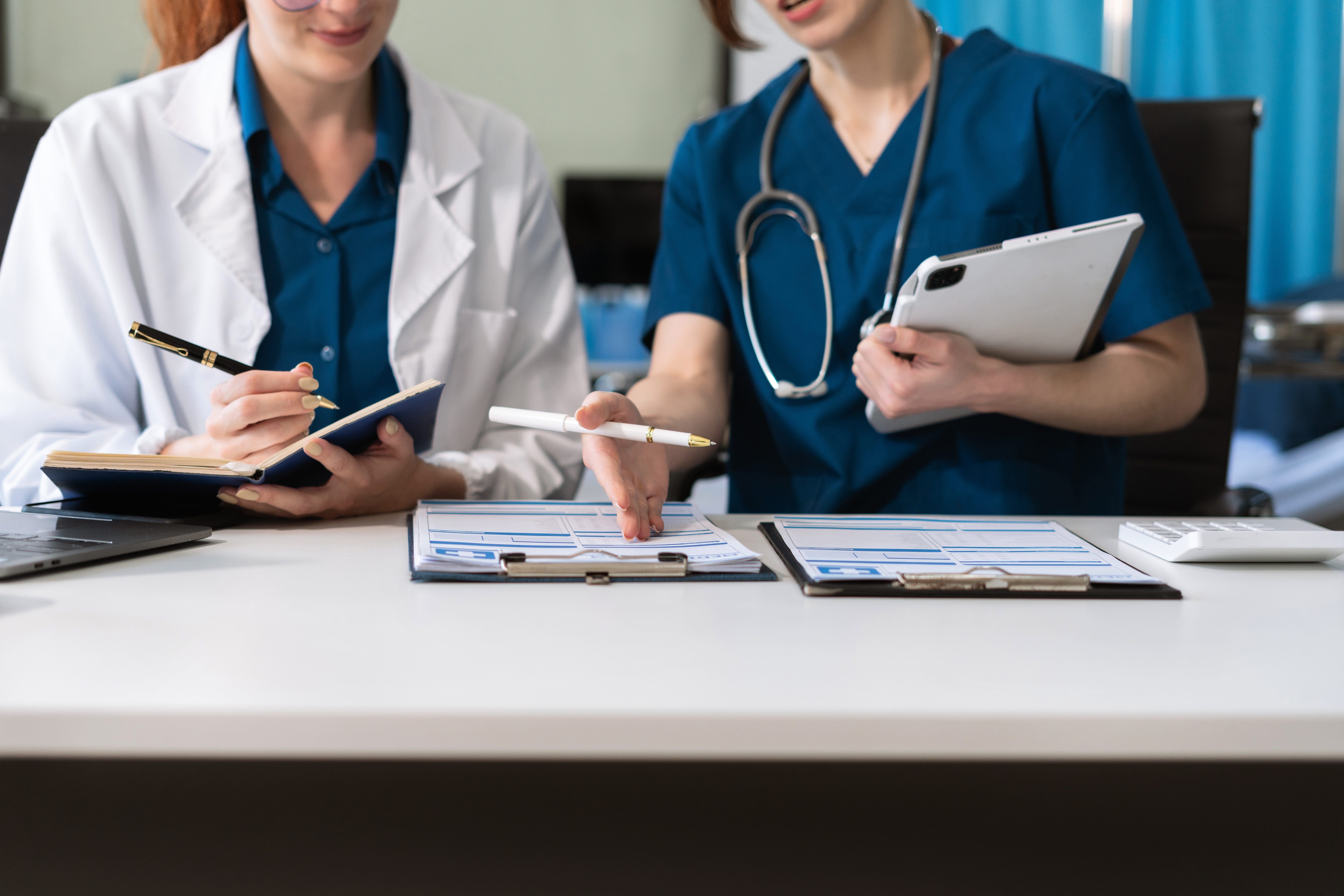 Mastering The Art Of Medical Writing For Oet Success 3 image of two medical professional discussing patient file—an illustrative image to describe OET medical writing courses by Accordemy®
