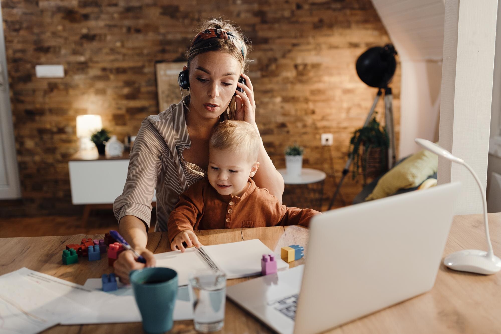 mid adult working mother taking notes during confe 083037c06a8ee4f1e465