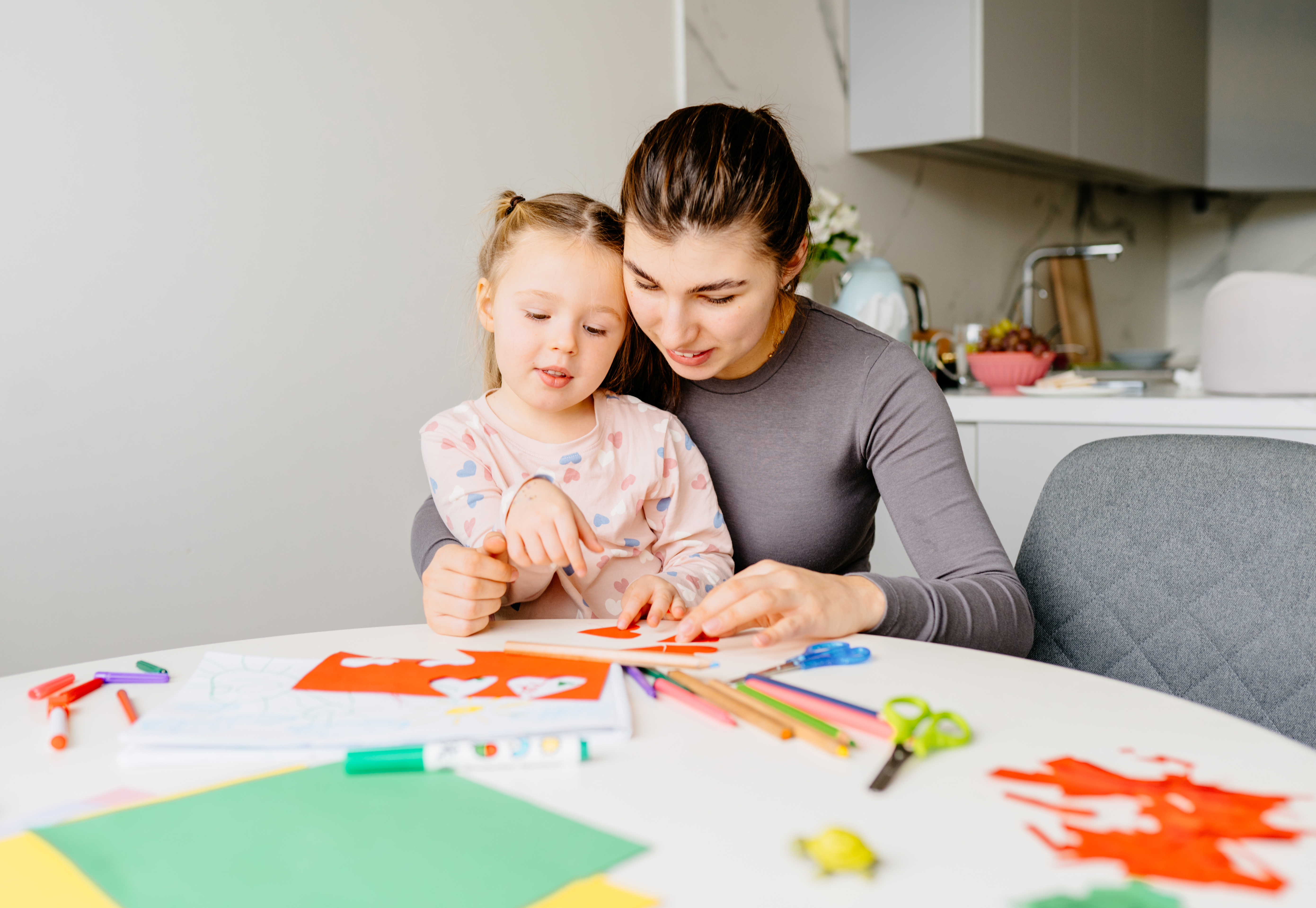 Mother helping daughter with craft