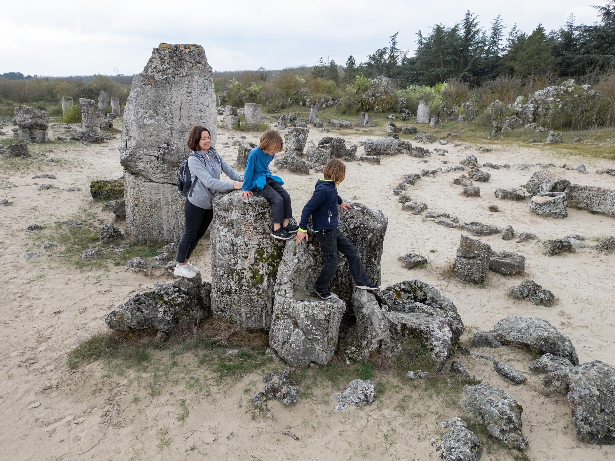 Hidden History by Road: 12 Lesser‑Known UK & Ireland Sites for Your Self‑Drive Itinerary 4 mother and two children explore rocky terrain in a b56a5b970c41458bfbc9 BTOURS
