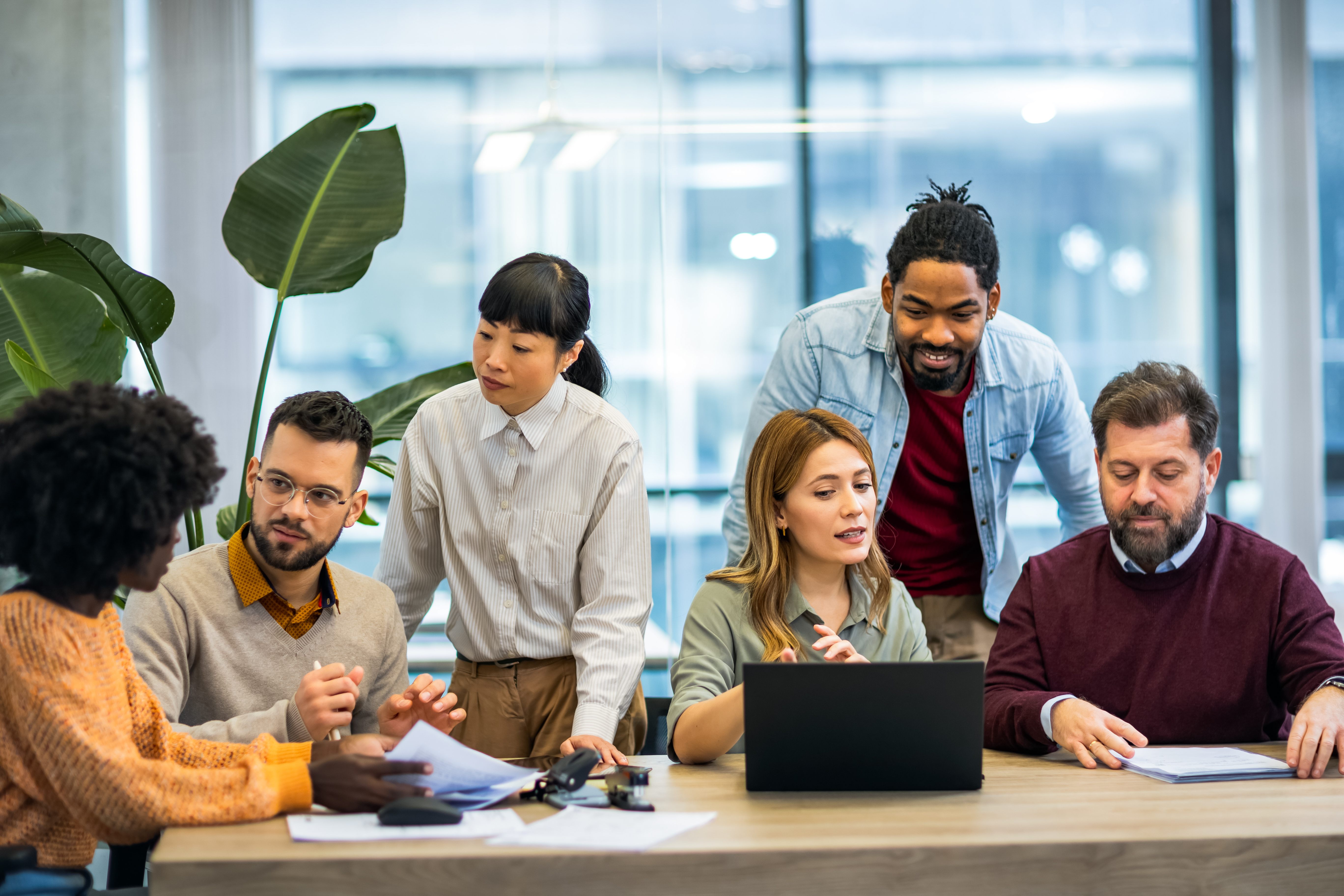 multiethnic colleagues standing around the laptop 0488cfa06d1702f69a50