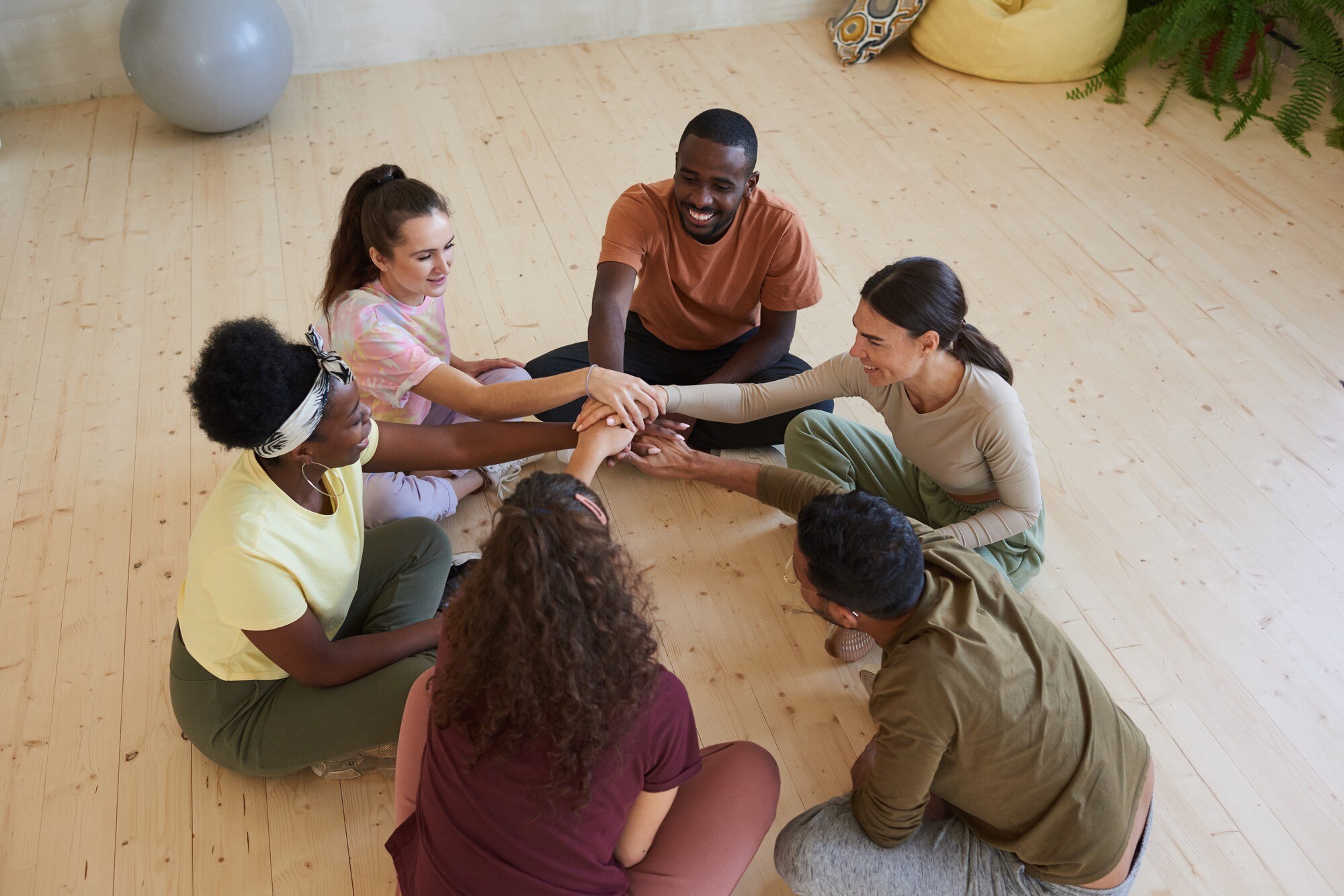 multiethnic group of people sitting on the floor i ce484e05988f59065edd