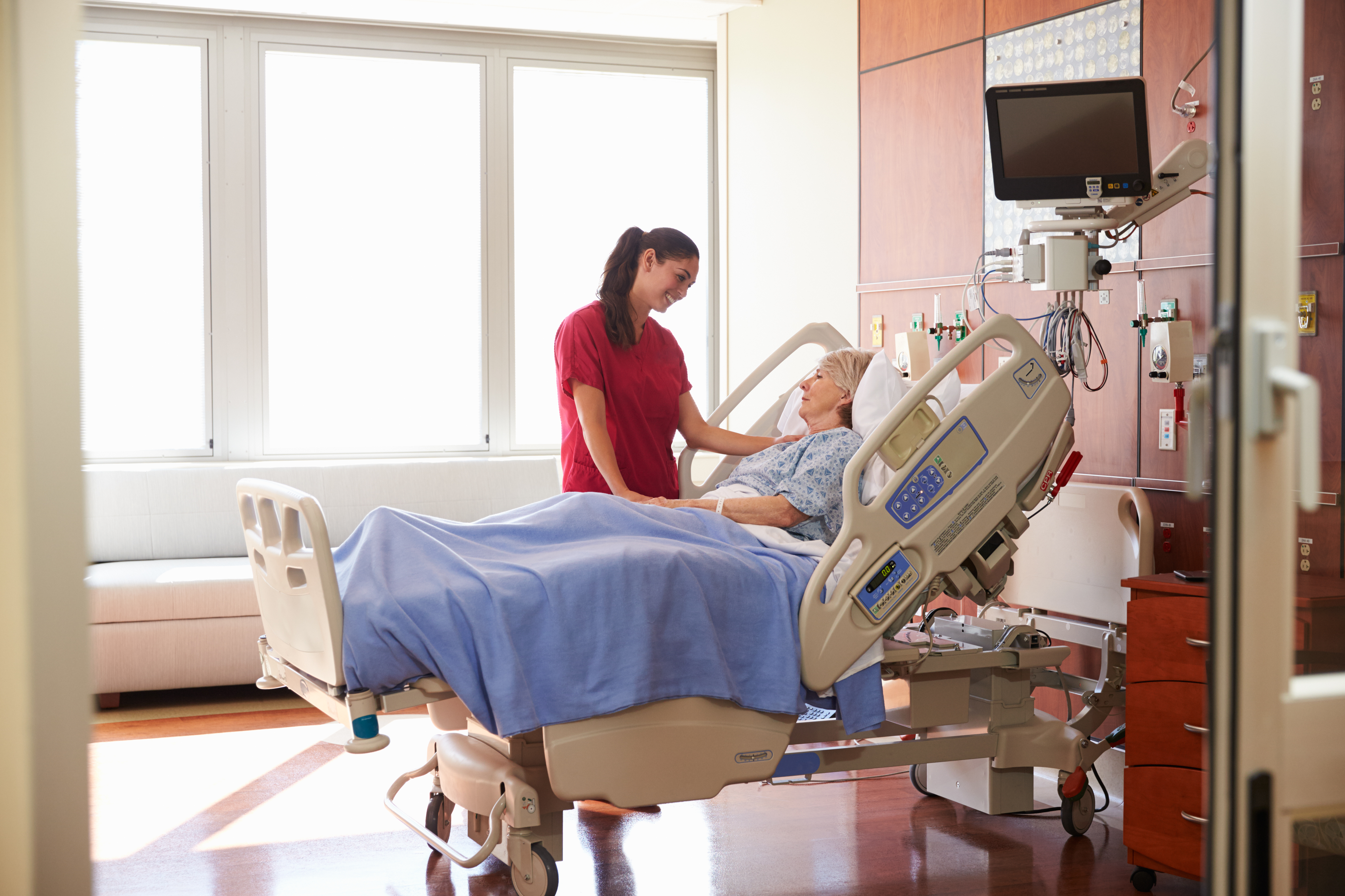 nurse talking to senior female patient in hospital 9e77a5ea6de37b17c59c