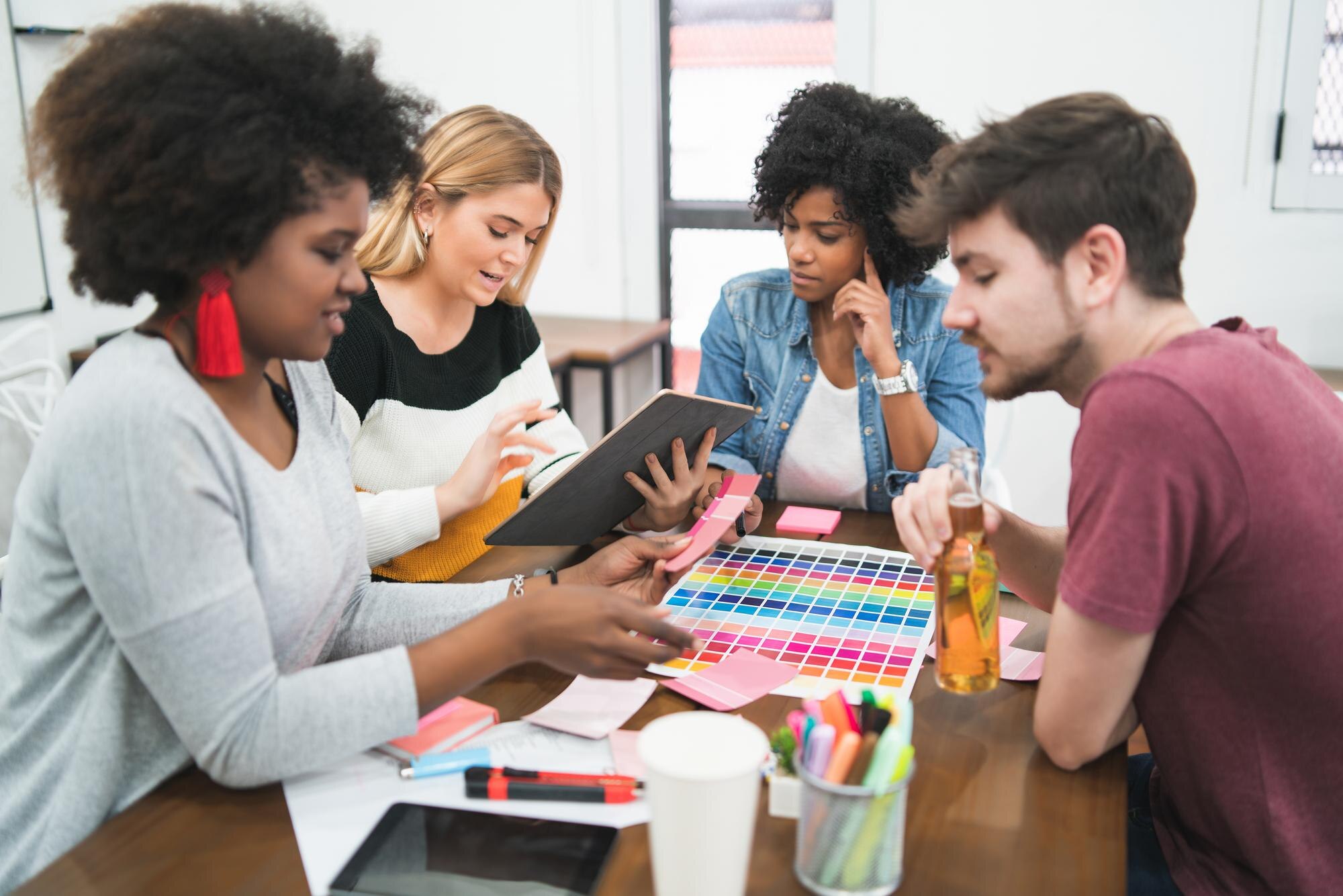 people working on table a525d8ca64e3243c0ea5