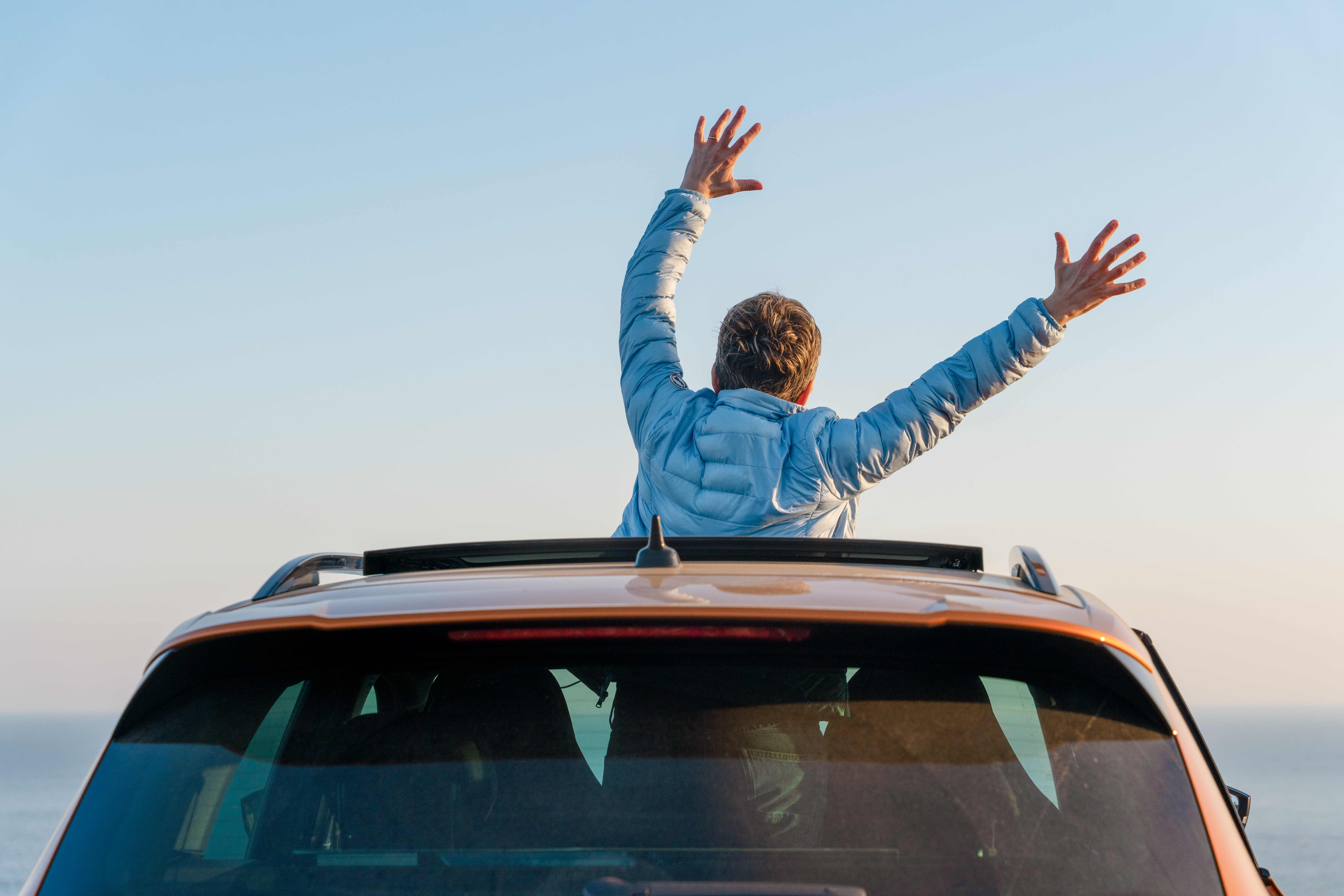 person celebrating on top of a car at a scenic coa 350ba18073c25132f424 BTOURS