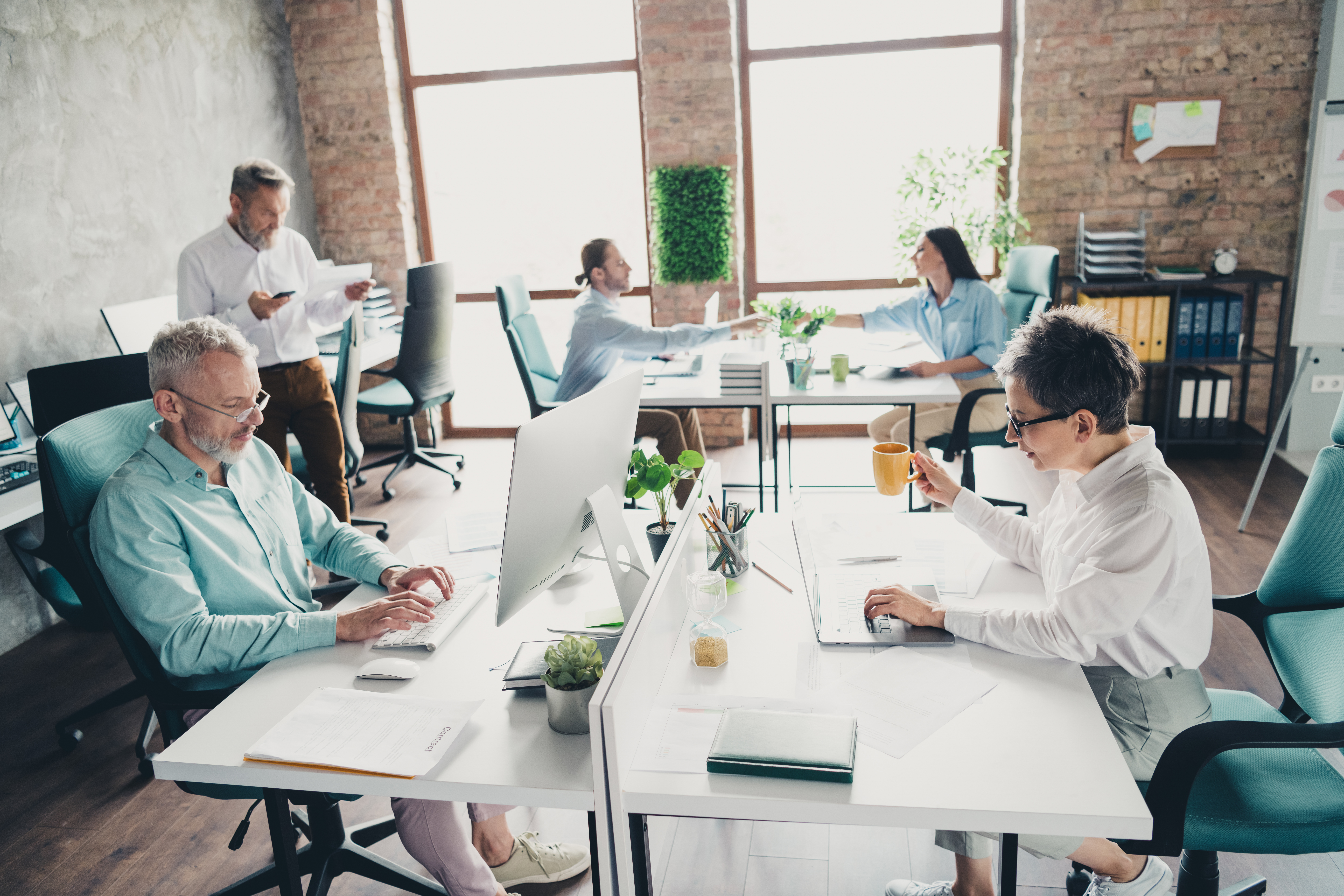 team of coworkers in an open work space sitting at their desks